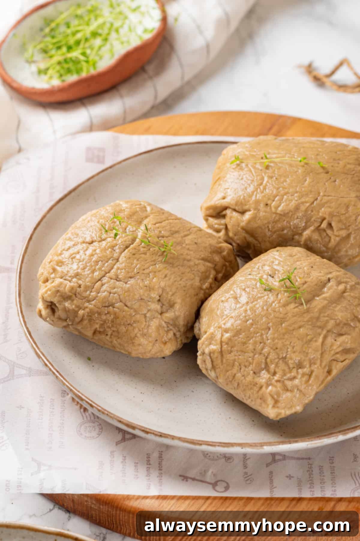 Three perfectly shaped vegan chicken breasts resting on a plate, ready for further preparation.