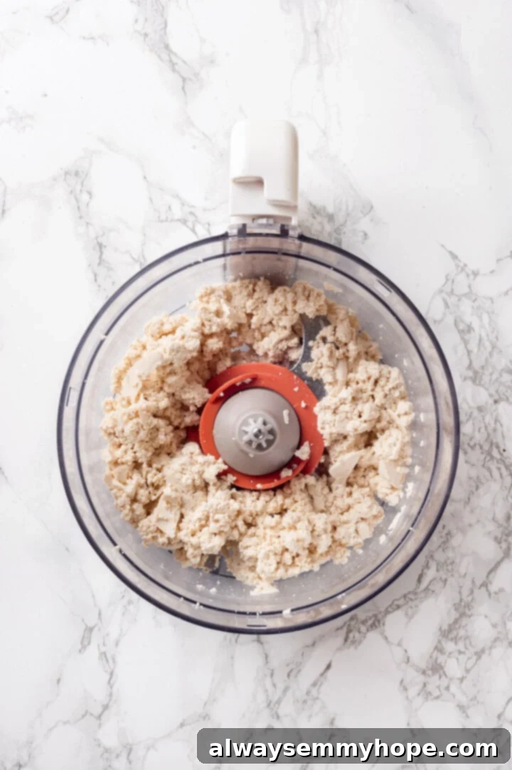 Drained and pressed extra-firm tofu ready to be processed in a food processor.