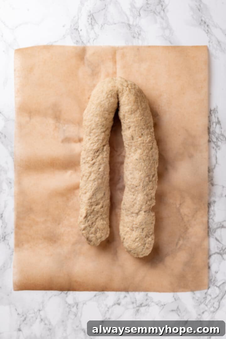 The vegan chicken log folded in half, demonstrating the technique for developing a fibrous texture.