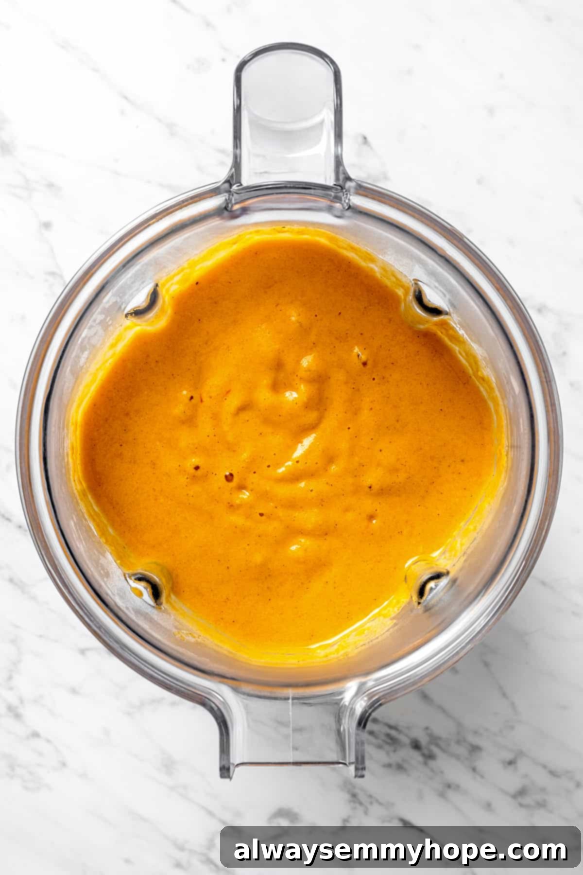 Smooth, pureed vegetables in a blender, forming the creamy base of the soup.