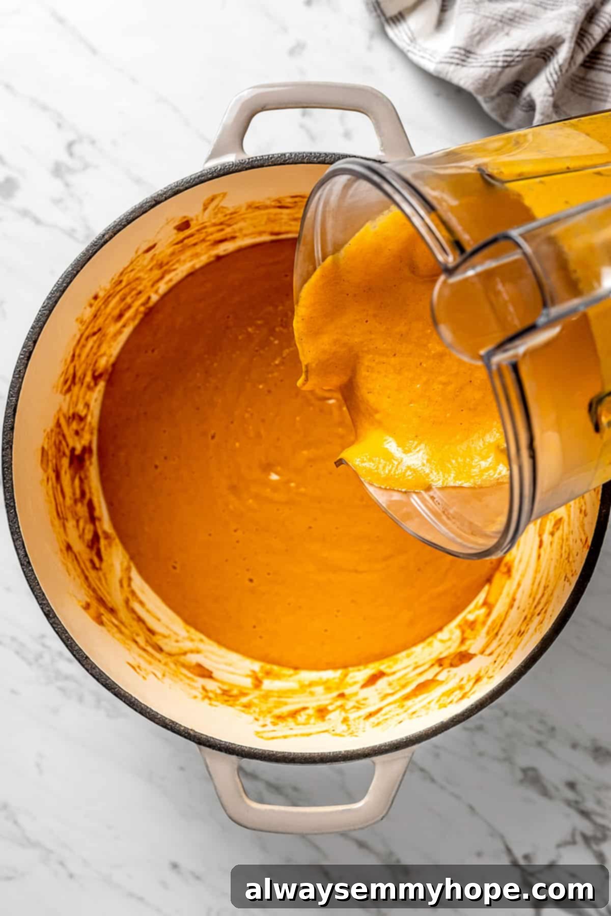Pouring the pureed vegetable mixture back into the large pot.