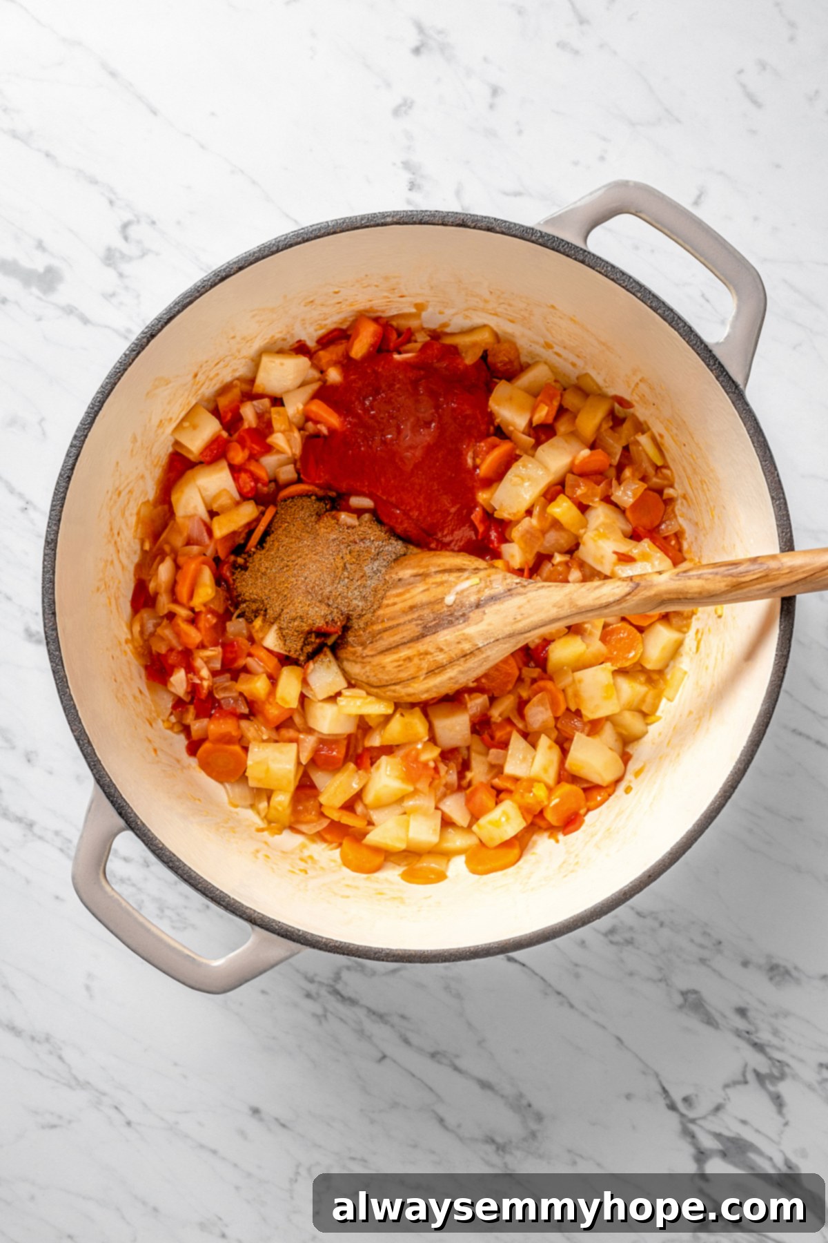Spice mixture being added to a pot of colorful, sautéed vegetables.