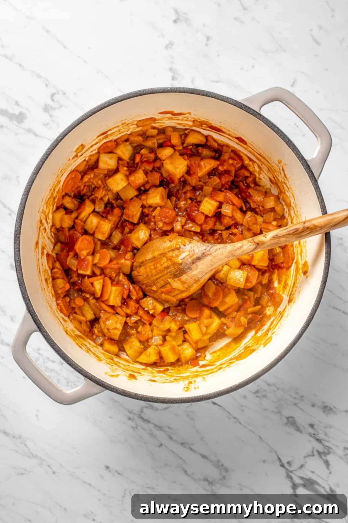 Sautéed vegetables and spices cooking together in a large pot, creating a rich base.