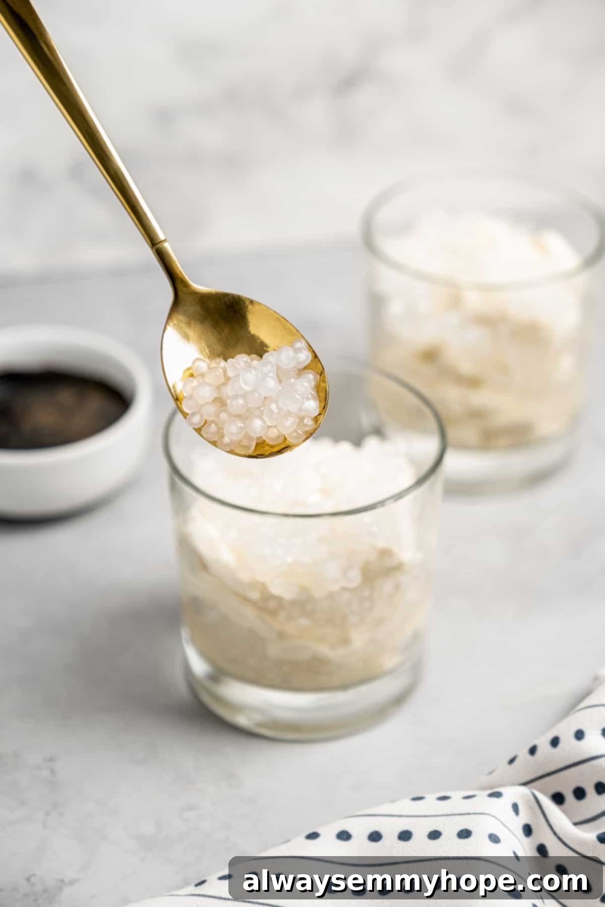 Spoonful of sago pearls with glasses of taho in background