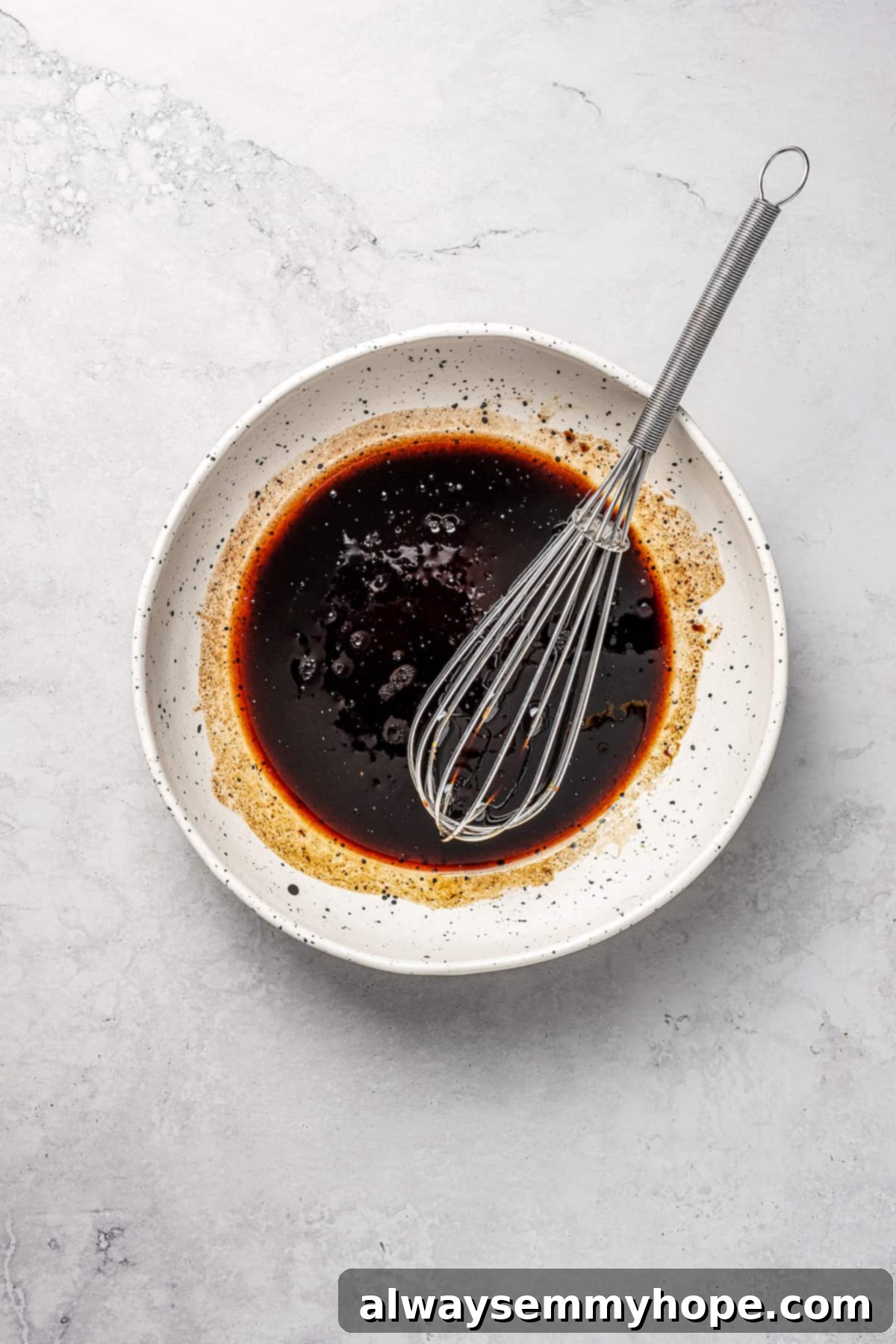 This vegan pad see ew pairs rice noodles, vegetables, and tofu with a sweet, savoury, and slightly tangy sauce for a restaurant-style meal! Overhead view of the tofu marinade ingredients being whisked together in a small bowl.