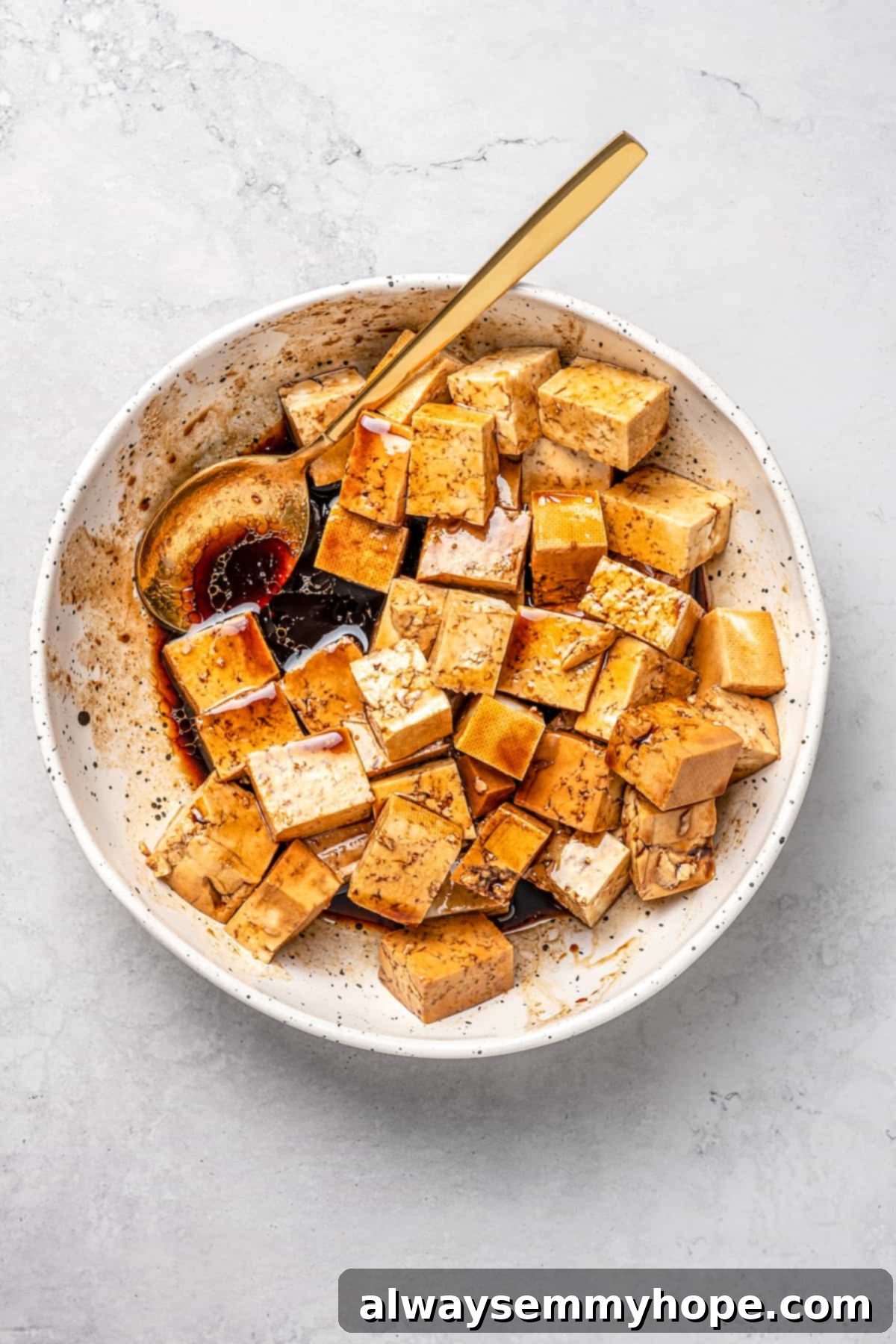 This vegan pad see ew pairs rice noodles, vegetables, and tofu with a sweet, savoury, and slightly tangy sauce for a restaurant-style meal! Overhead view of tofu slices marinating in a shallow dish, covered with the savory sauce mixture.