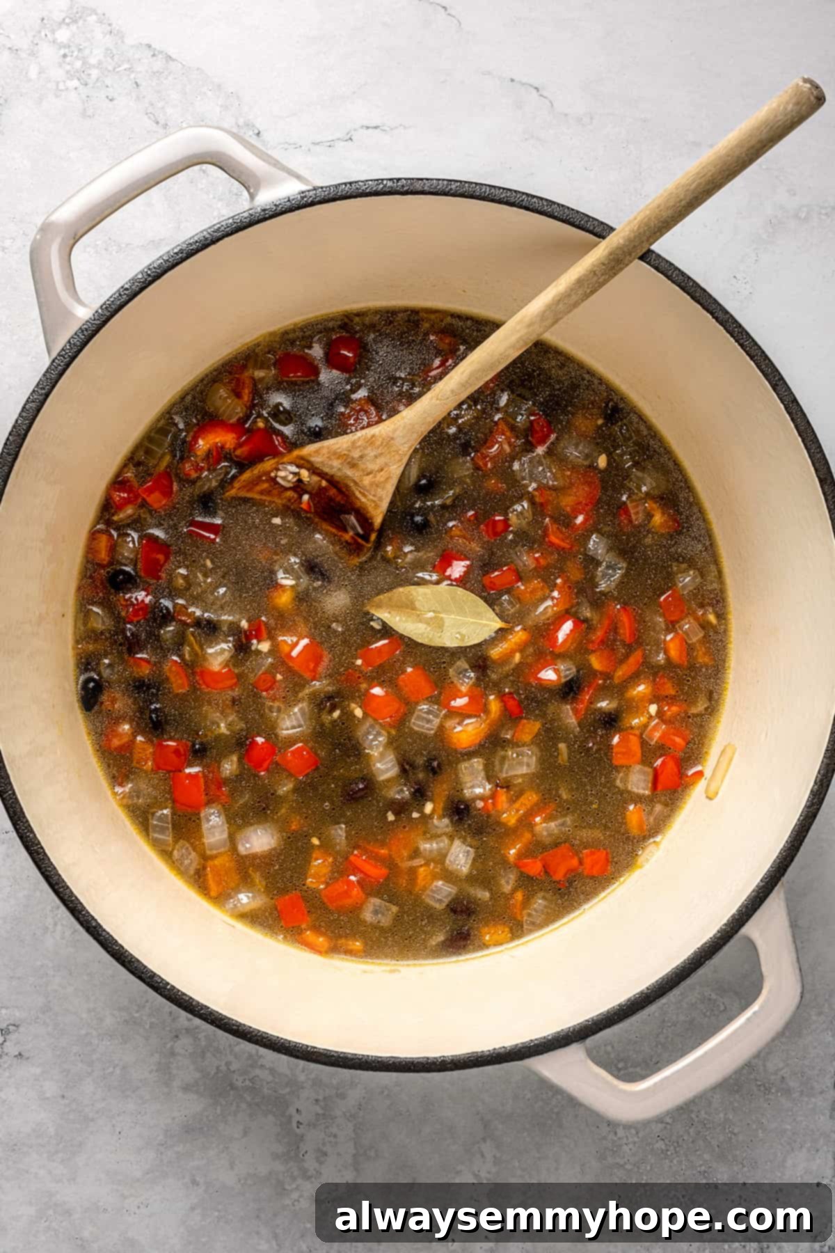 Overhead view of congri after adding liquid and bay leaf