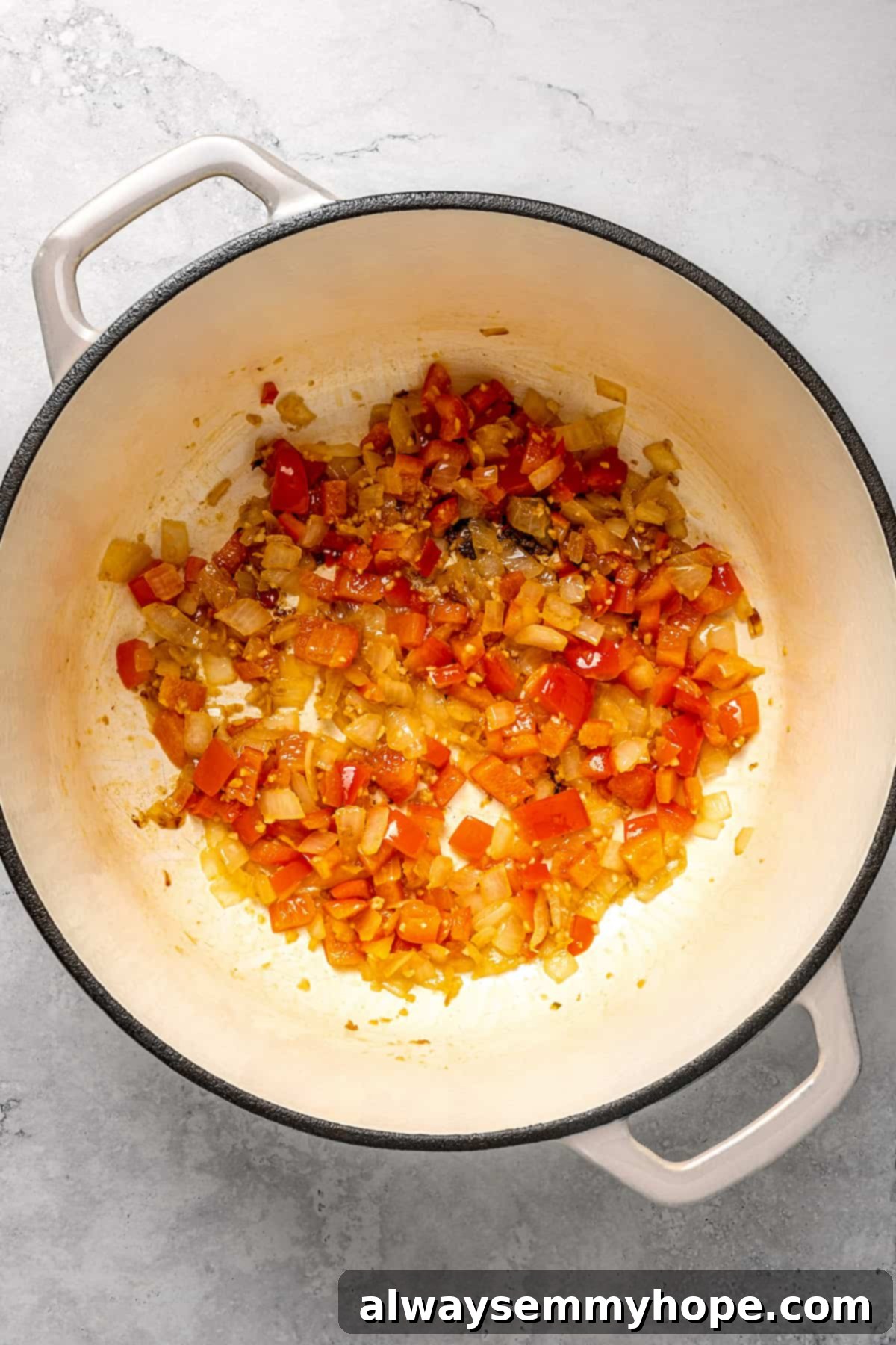 Onions and red peppers cooking in pot