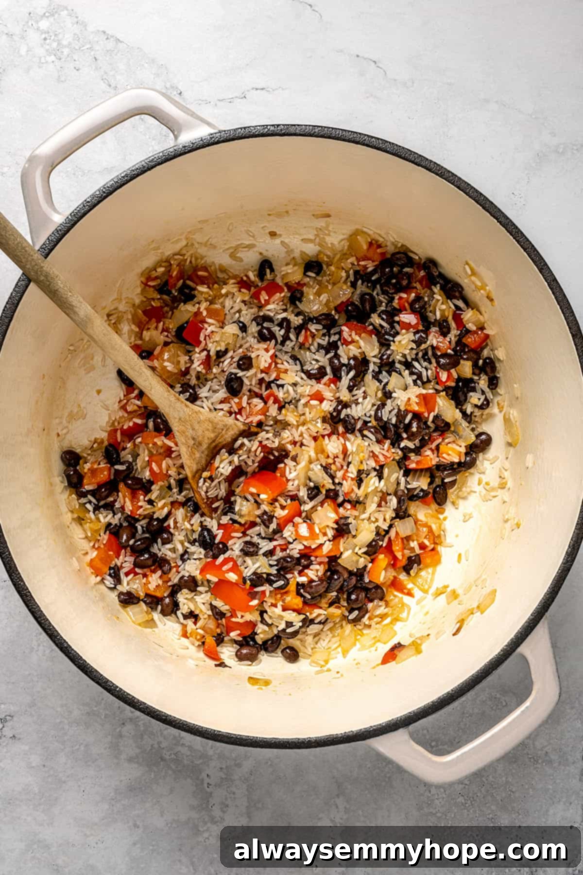 Stirring rice, beans, and peppers in pot