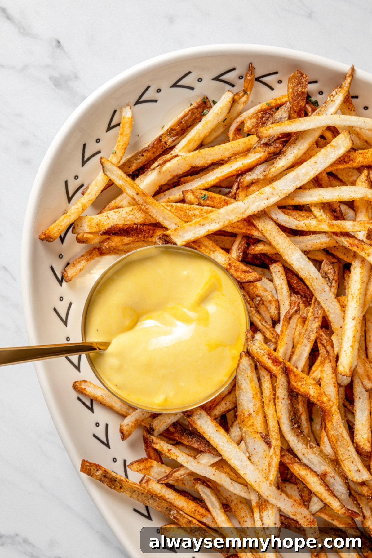 The air fryer makes these shoestring fries perfectly crispy without all the oil, and my blend of savoury seasonings makes them irresistible! Overhead view of air fryer shoestring fries with dipping sauce