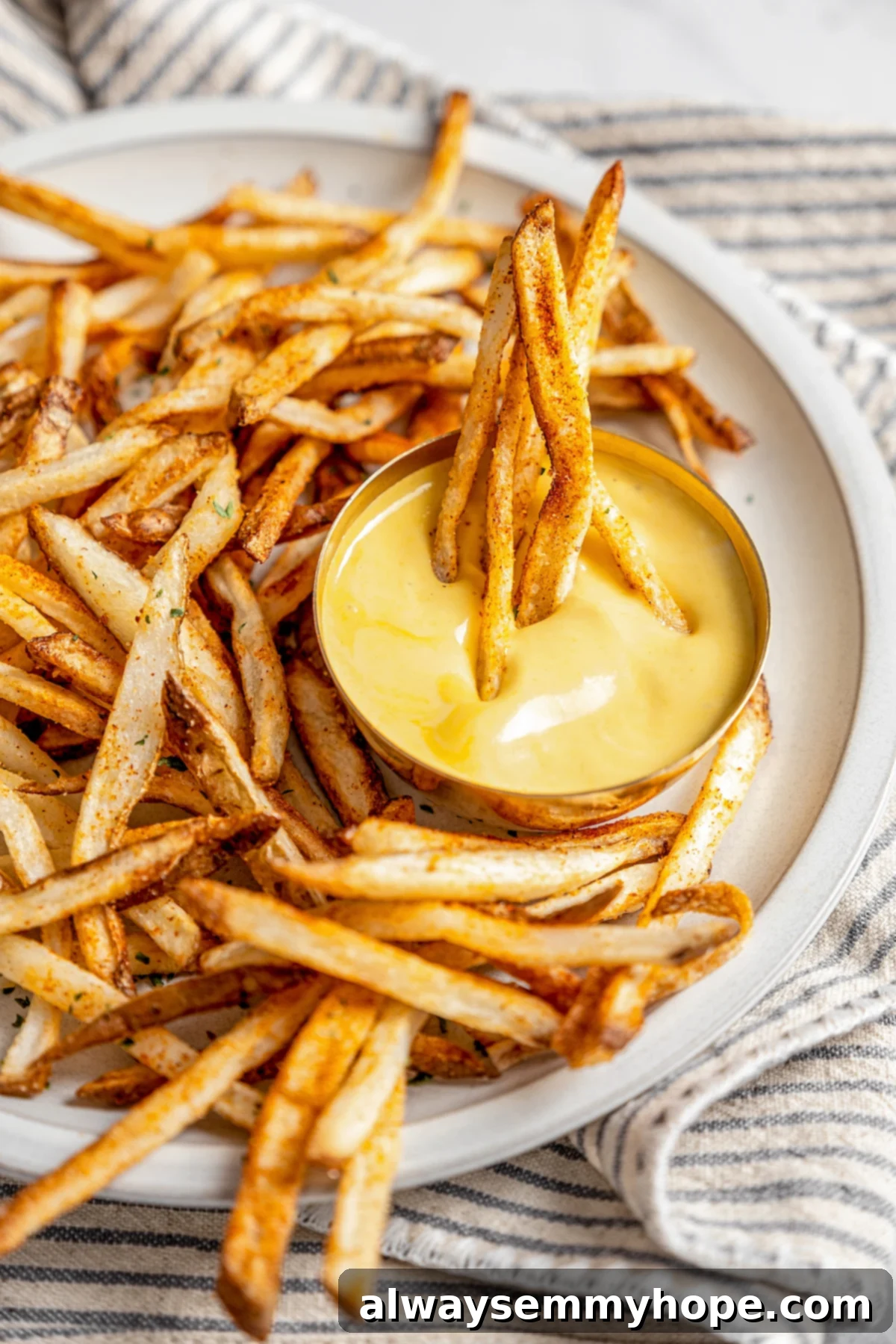 The air fryer makes these shoestring fries perfectly crispy without all the oil, and my blend of savoury seasonings makes them irresistible! Plate of shoestring fries with dipping sauce