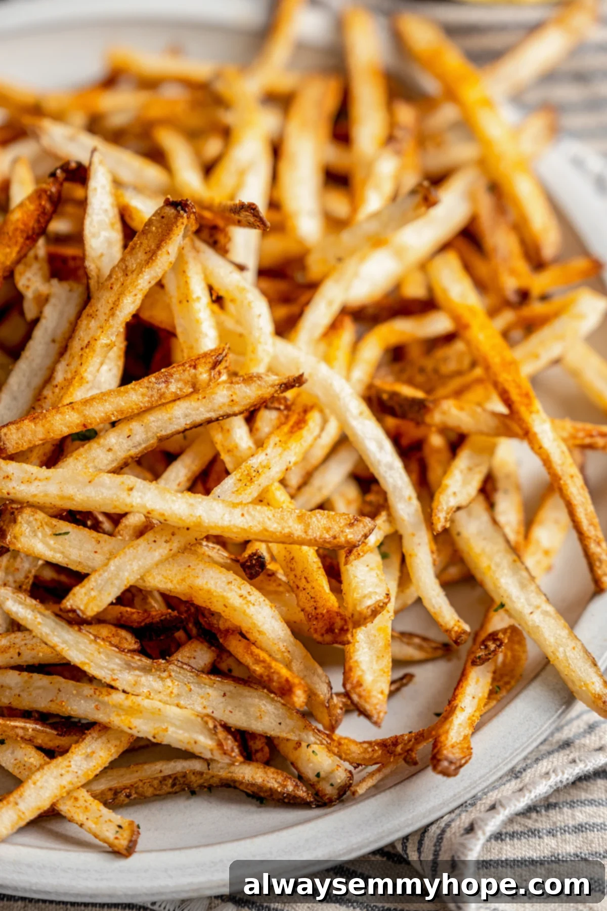 The air fryer makes these shoestring fries perfectly crispy without all the oil, and my blend of savoury seasonings makes them irresistible! Shoestring fries piled on plate