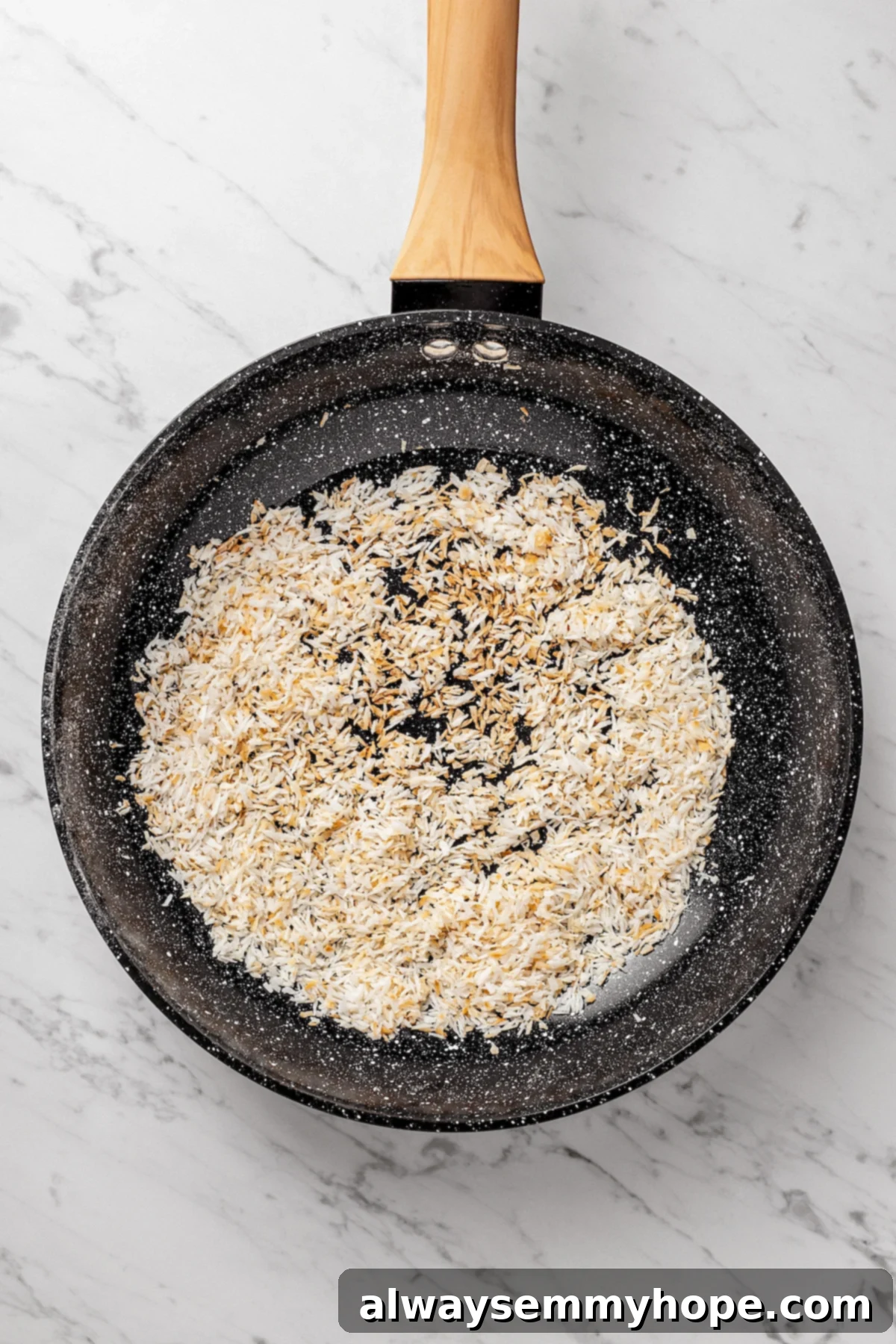 Toasting Shredded Coconut for Enhanced Flavor Overhead view of shredded coconut being toasted to a golden brown in a small skillet.