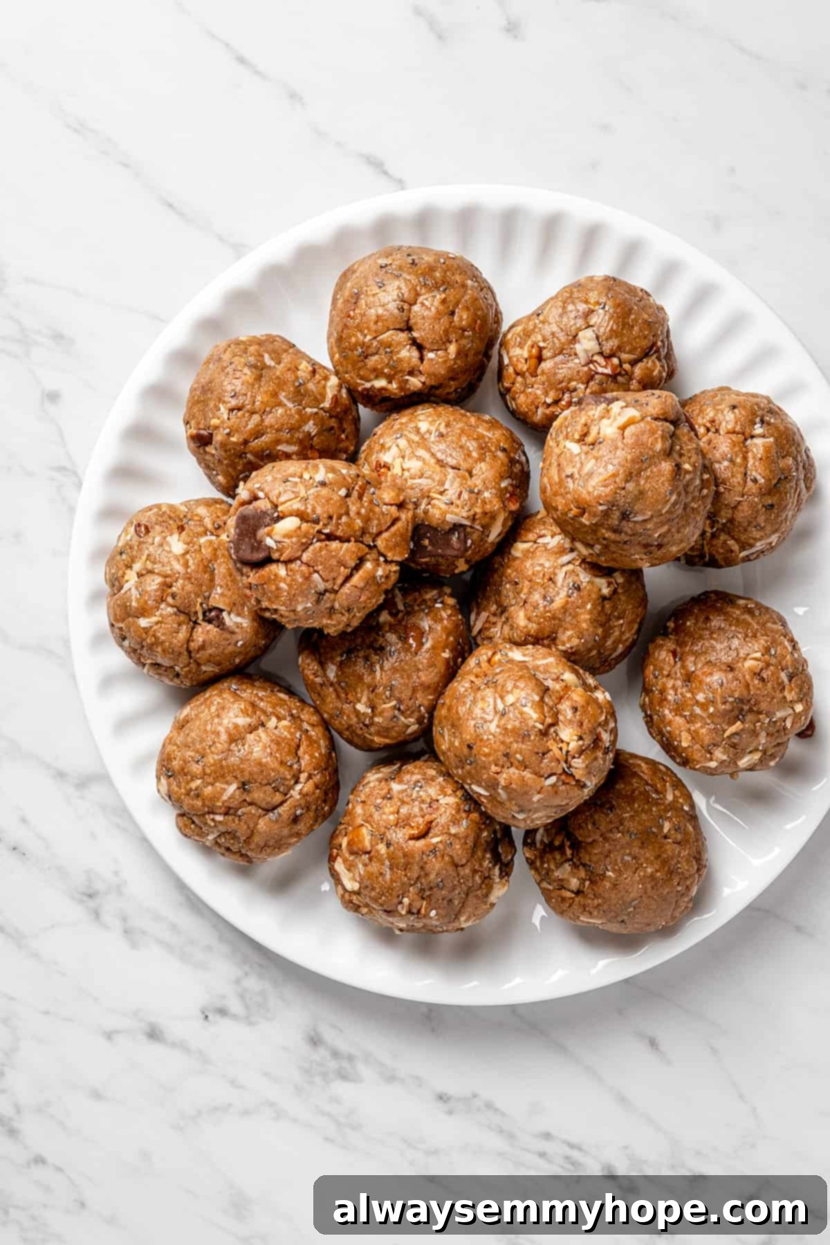 Forming Vegan Lactation Cookie Dough Balls Overhead view of perfectly rounded balls of vegan lactation cookie dough, flattened slightly, spaced on a parchment-lined baking sheet before baking.