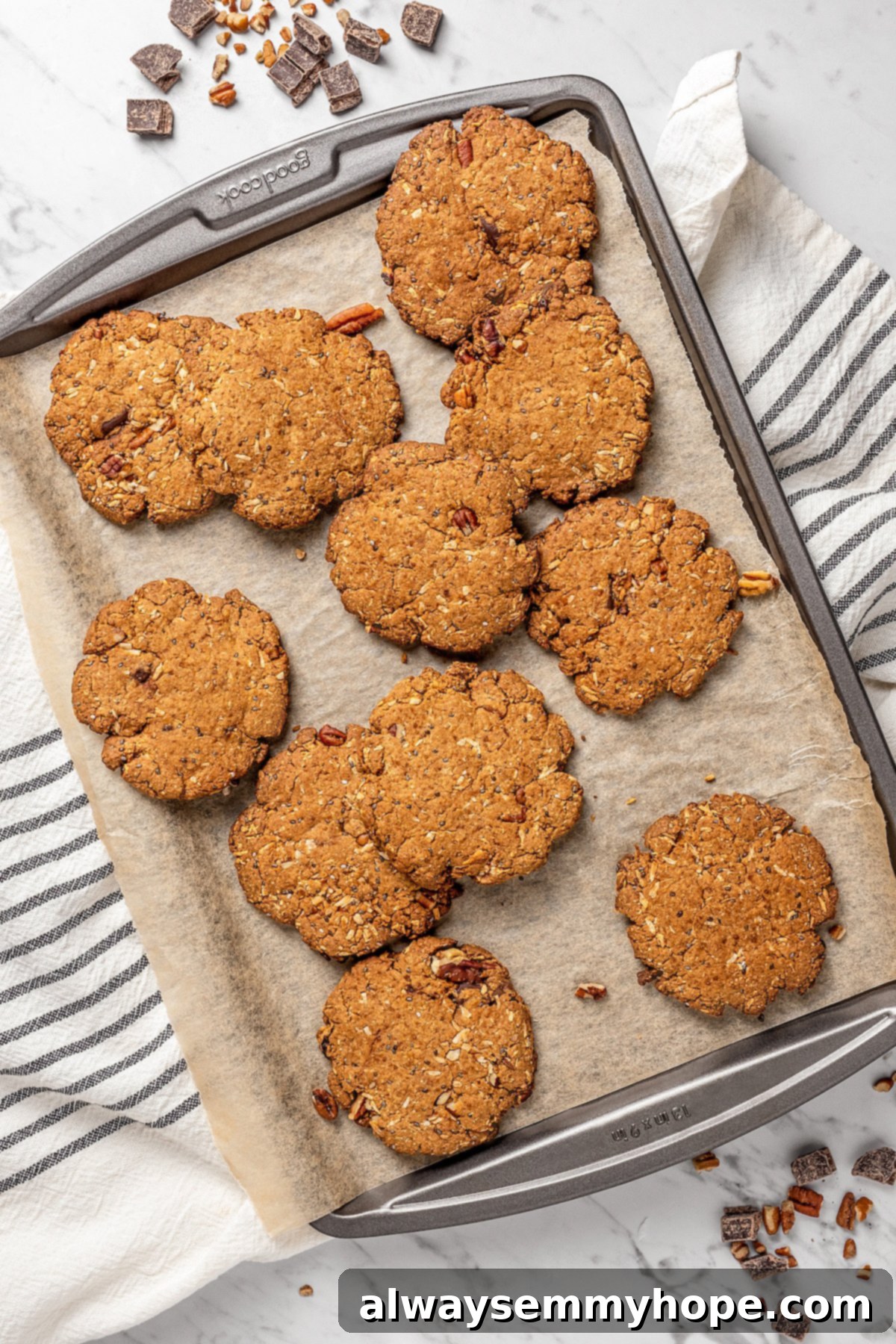 Perfect Batch of Vegan Lactation Cookies Cooling Down Overhead view of a baking sheet with an array of freshly baked, golden-brown vegan lactation cookies cooling on parchment paper.