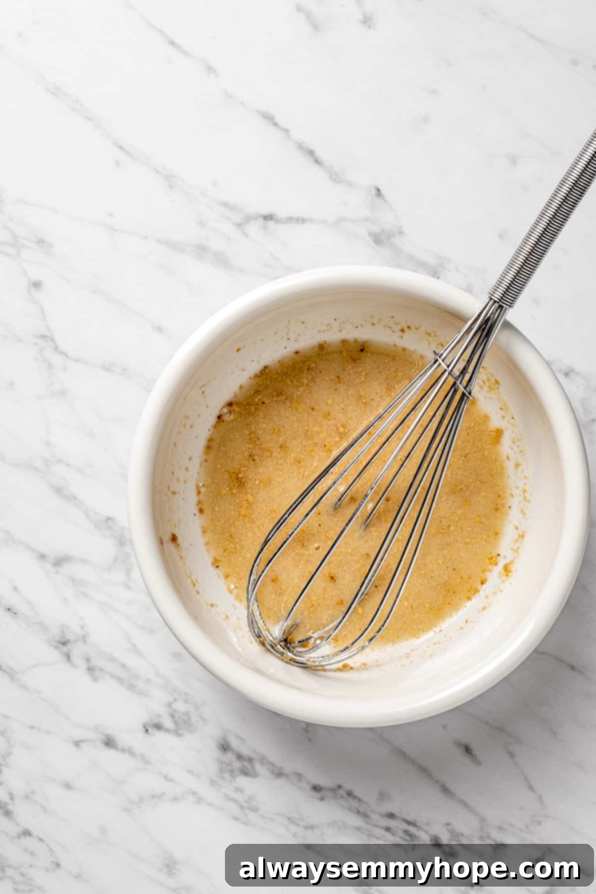 Preparing the Flax Egg for Vegan Lactation Cookies Overhead view of a whisk in a small glass bowl containing the thickening flax egg mixture.