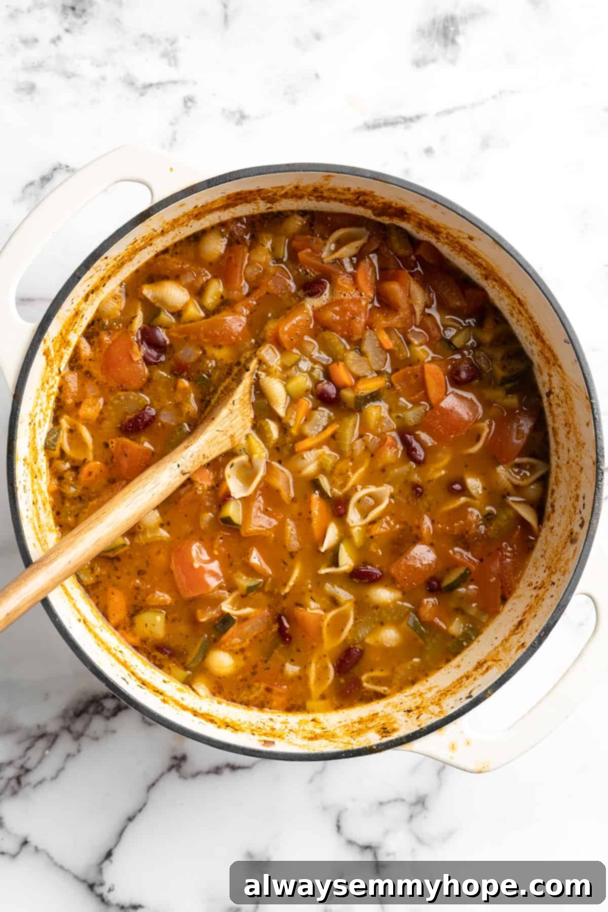 This vegetable minestrone soup is hearty comfort food at its best! Load it with veggies, beans, and pasta and enjoy a cozy one-pot meal. Overhead view of vegan minestrone soup in pot