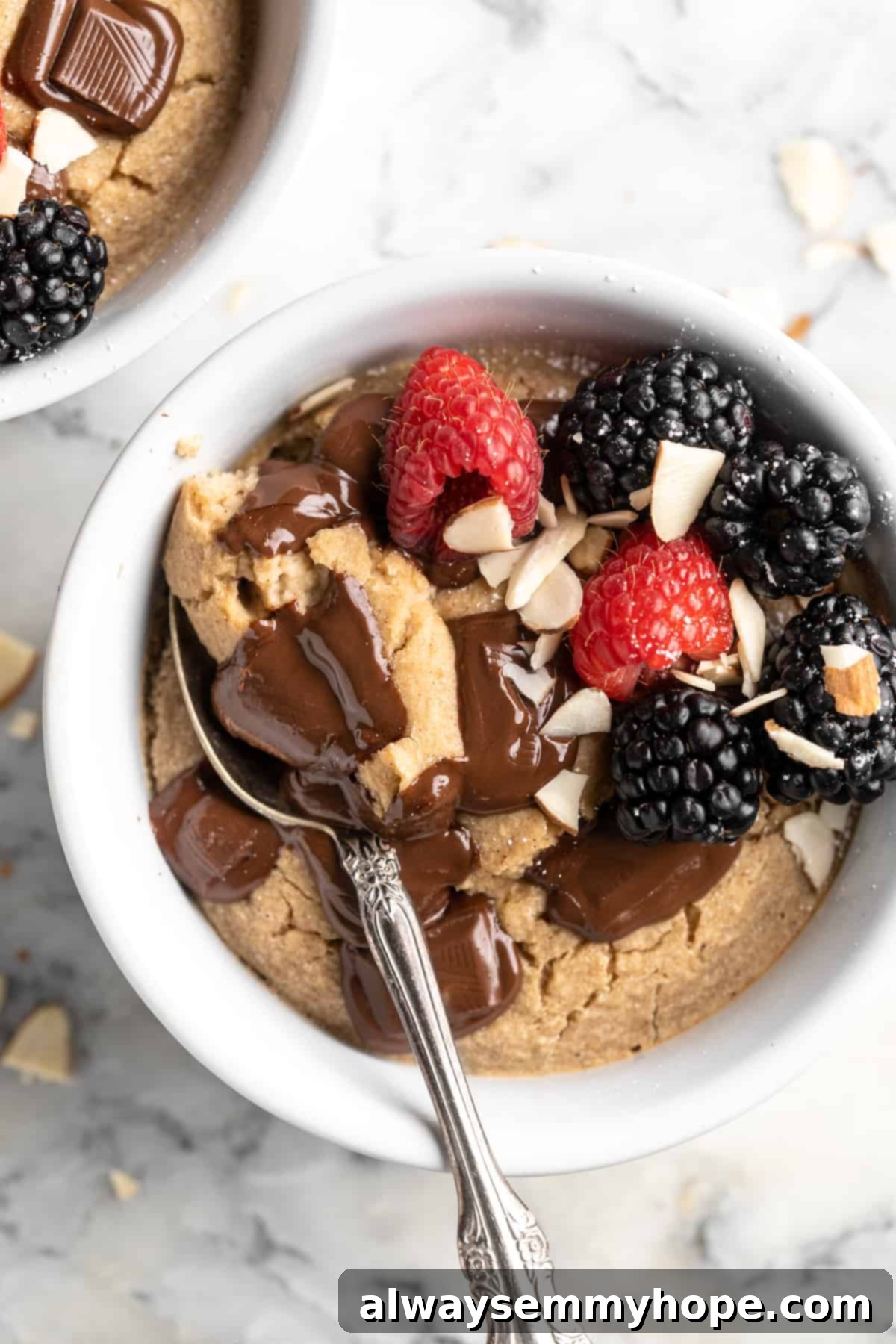 These TikTok vegan baked oats are a filling breakfast, with just a little bit of decadence thanks to the addition of dark chocolate. So easy! Overhead view of vegan TikTok baked oats with berries, chocolate, and sliced almonds