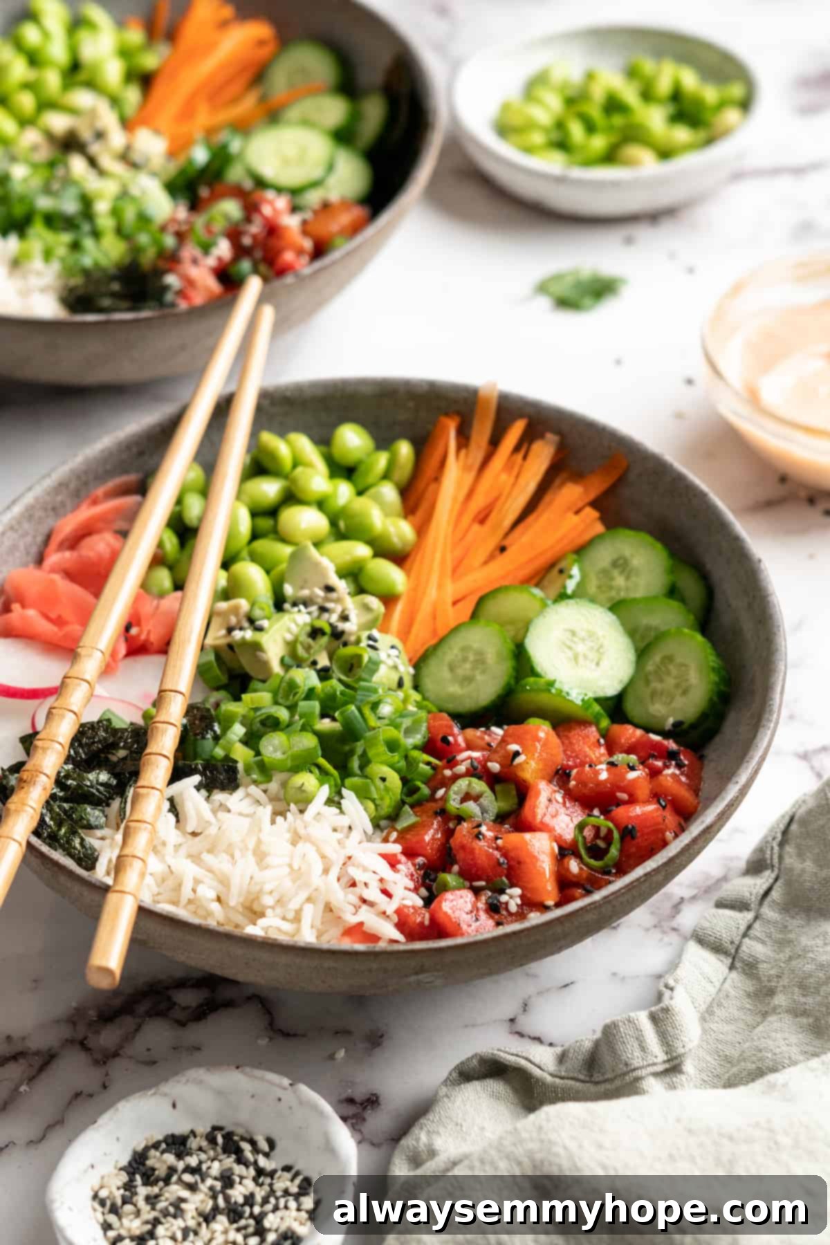 These easy vegan poke bowls are full of colour and flavour! Top a base of rice with watermelon tuna and an array of fresh toppings. So good! Two vegan poke bowls with watermelon tuna, surrounded by various fresh toppings and garnishes
