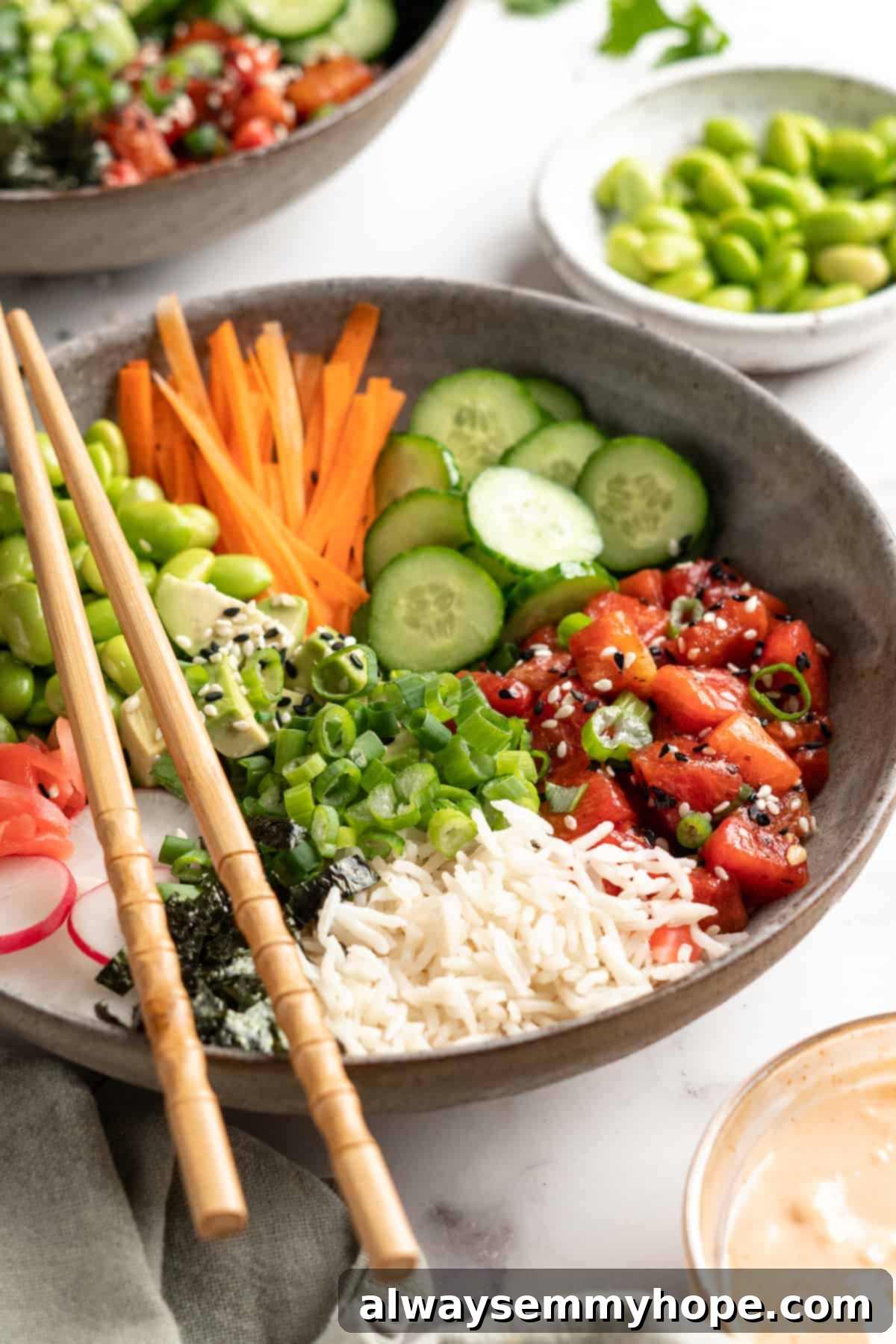 These easy vegan poke bowls are full of colour and flavour! Top a base of rice with watermelon tuna and an array of fresh toppings. So good! Vegan poke bowl with watermelon tuna, served with chopsticks and a side of fresh ingredients