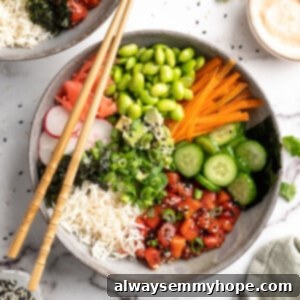 Overhead view of vegan poke bowl with chopsticks on top, surrounded by toppings and garnishes