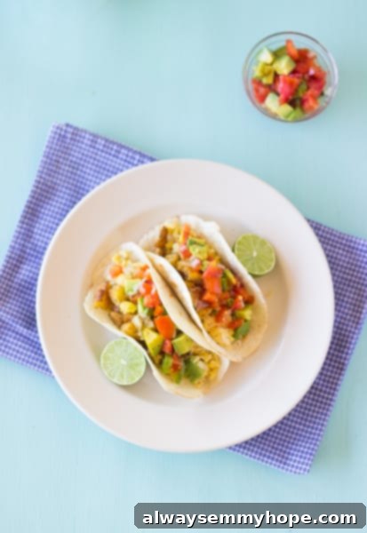 Mexican Breakfast Tacos are a hearty breakfast packed with hash potatoes, eggs and avocado pico de gallo salsa. Fresh and zesty! Breakfast tacos on a white plate.
