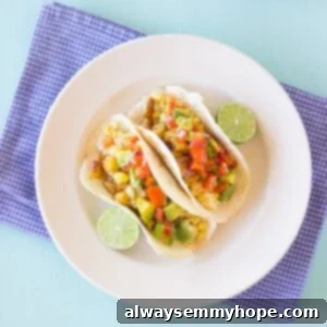 Breakfast Tacos with Fresh Avocado Pico 3 Top down shot of tacos on a white plate.