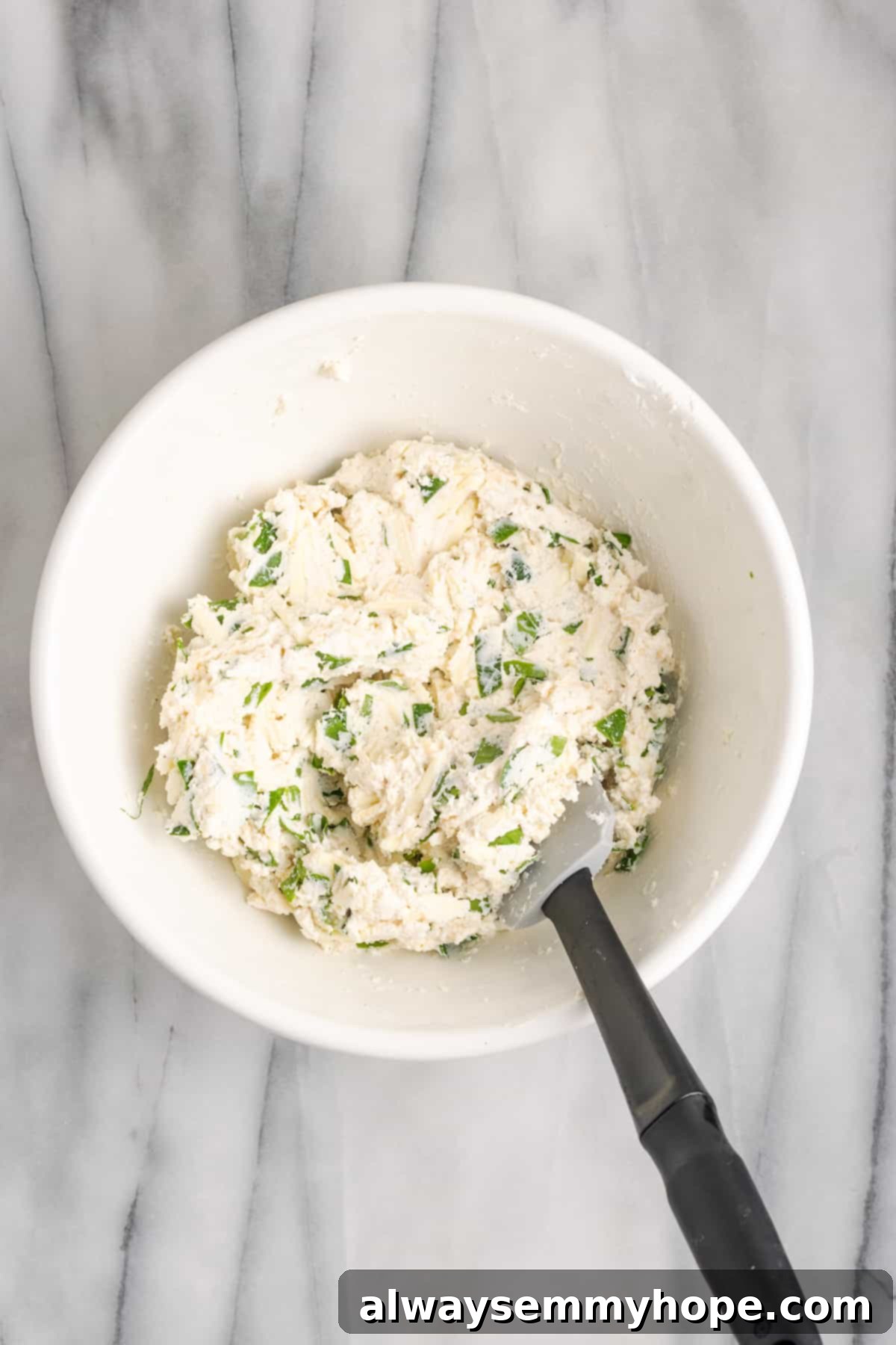 A bowl of rich, dairy-free spinach and ricotta filling, perfectly seasoned and ready for stuffing the manicotti. Close-up overhead view of a bowl filled with creamy vegan ricotta and spinach mixture, ready to be piped into manicotti shells.