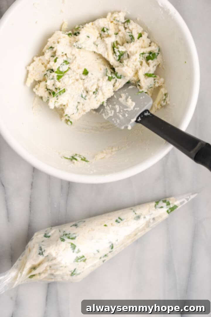 Piping the delicious vegan spinach ricotta filling into the manicotti shells. The creamy vegan spinach ricotta filling prepared in a bowl and being transferred to a piping bag for easy stuffing of the manicotti shells.
