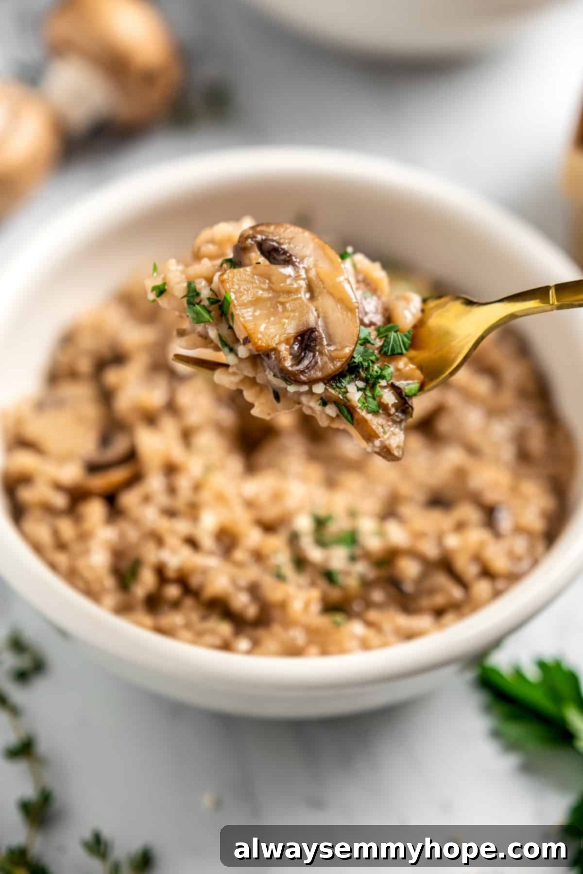 A forkful of creamy vegan Instant Pot risotto held above a bowl, showcasing the perfect texture and inviting appearance of the dish