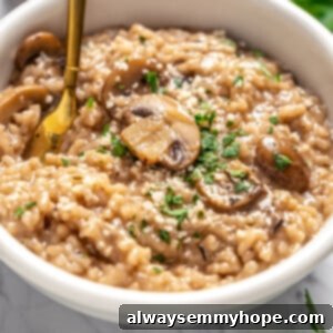 White bowl with creamy vegan Instant Pot mushroom risotto and a gold spoon, ready to eat