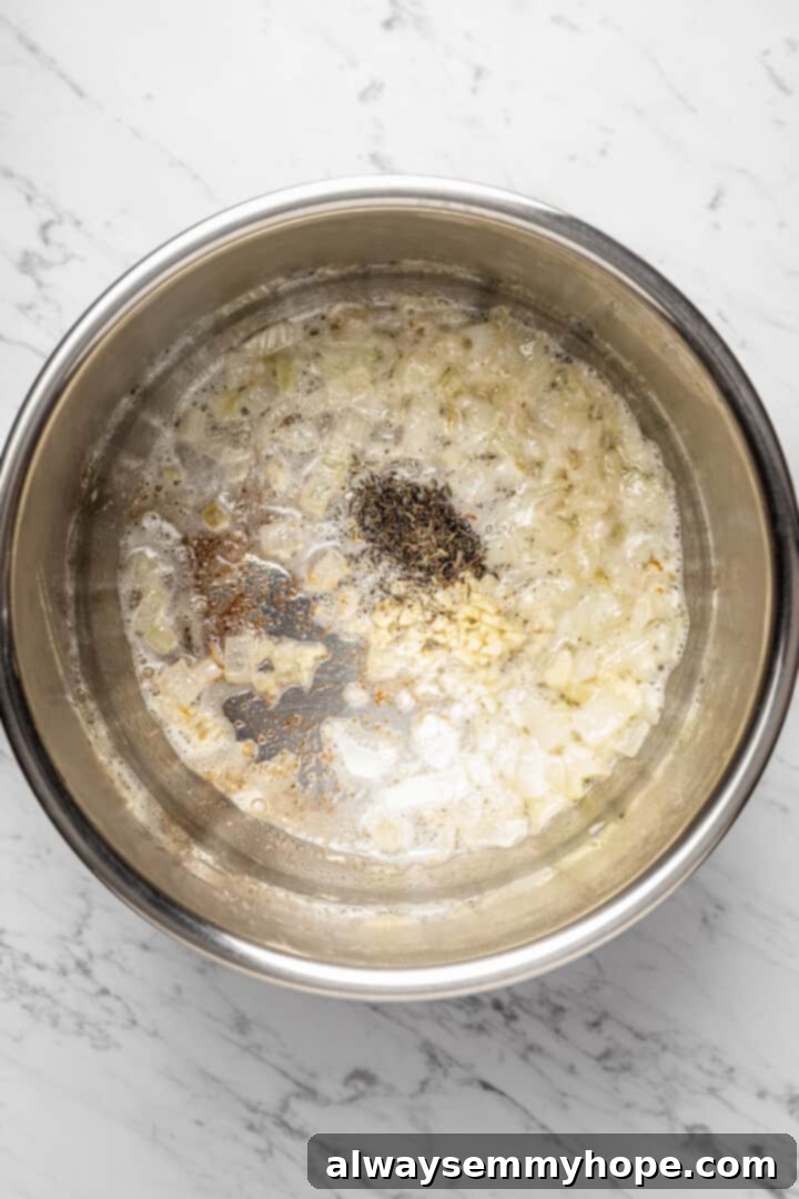 Overhead view of sautéed onions with finely chopped garlic and dried thyme cooking in the Instant Pot insert, releasing fragrant aromas