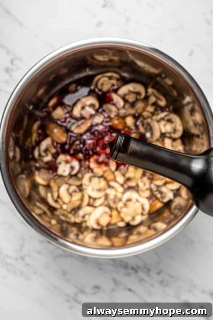A stream of red wine being poured into the Instant Pot insert, mingling with the sautéed risotto ingredients