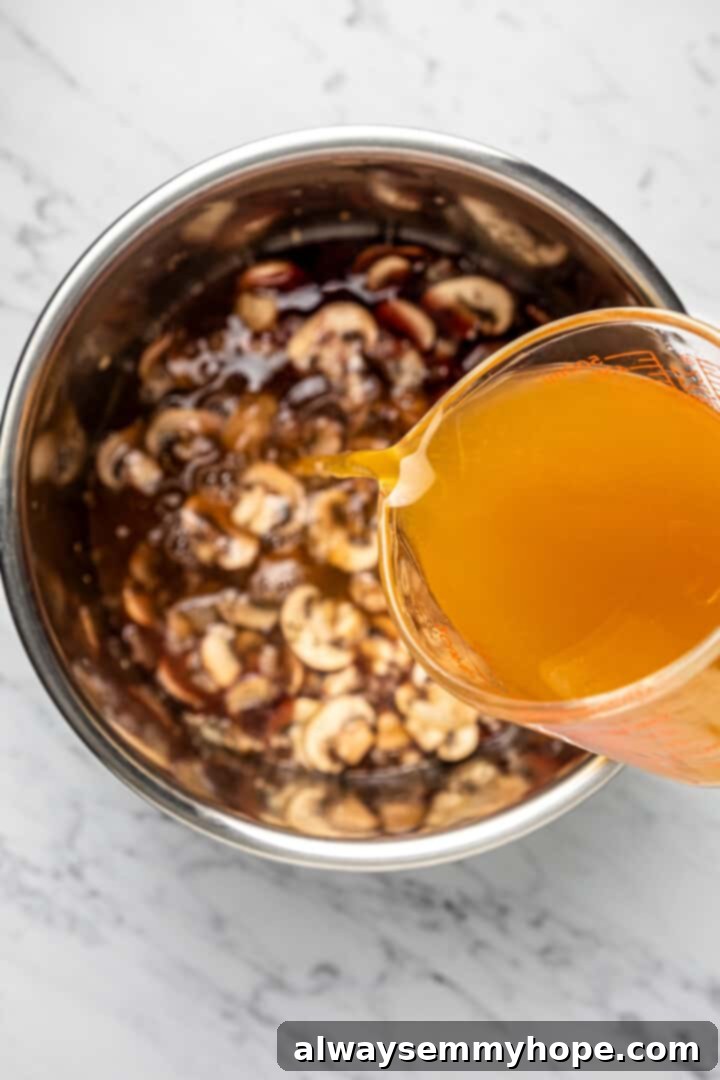 Vegetable broth being carefully poured into the Instant Pot insert, joining the red wine and other fragrant risotto ingredients