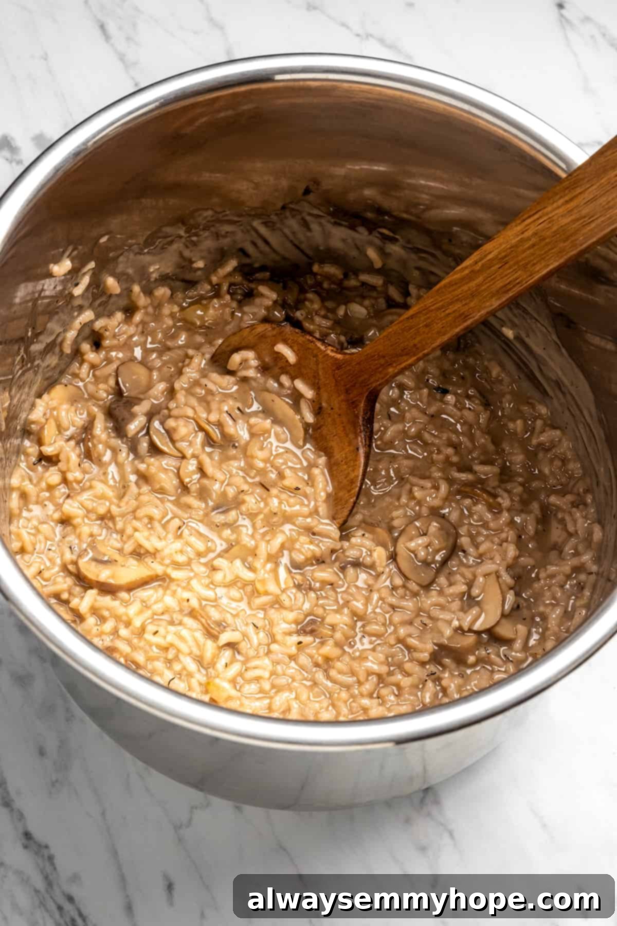 Overhead view of freshly cooked vegan risotto in the Instant Pot insert, still hot and steamy, ready for a final stir and seasoning