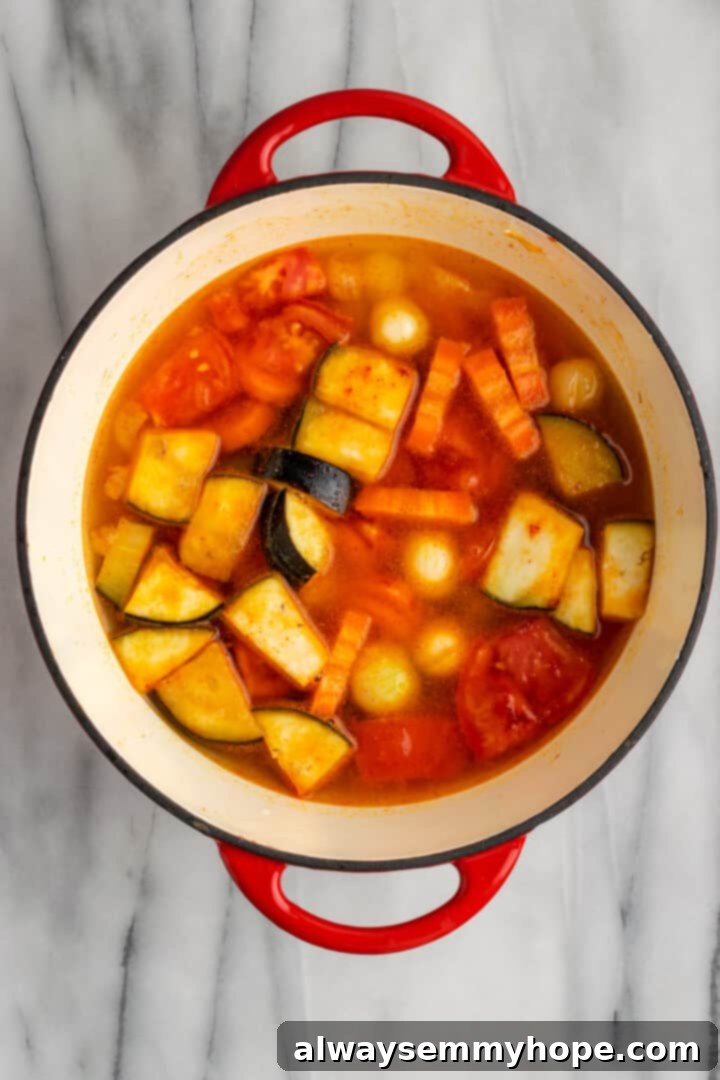 This vegan sambar is just like the sambar at your favourite Indian restaurant! Here's how to make this hearty lentil and veggie stew at home. Overhead view of vegetables in Dutch oven with water