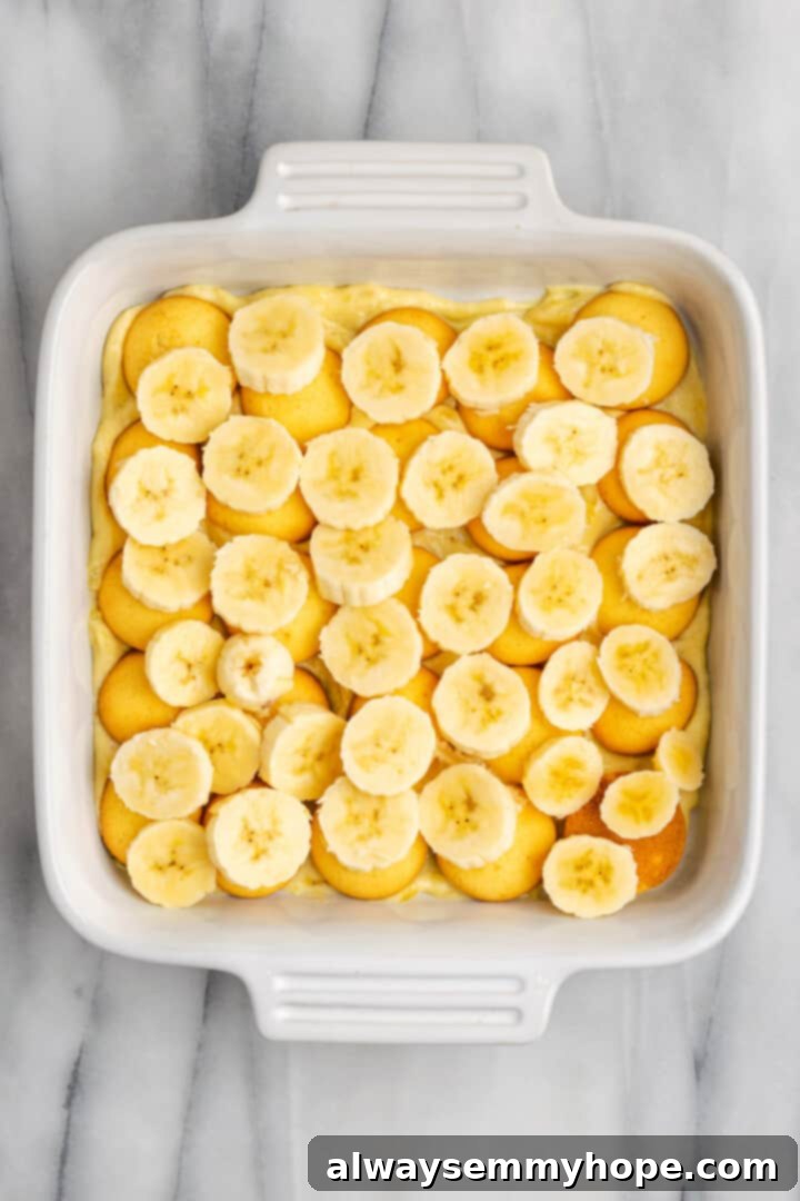 Layer of sliced bananas and vanilla wafers in baking dish for banana pudding