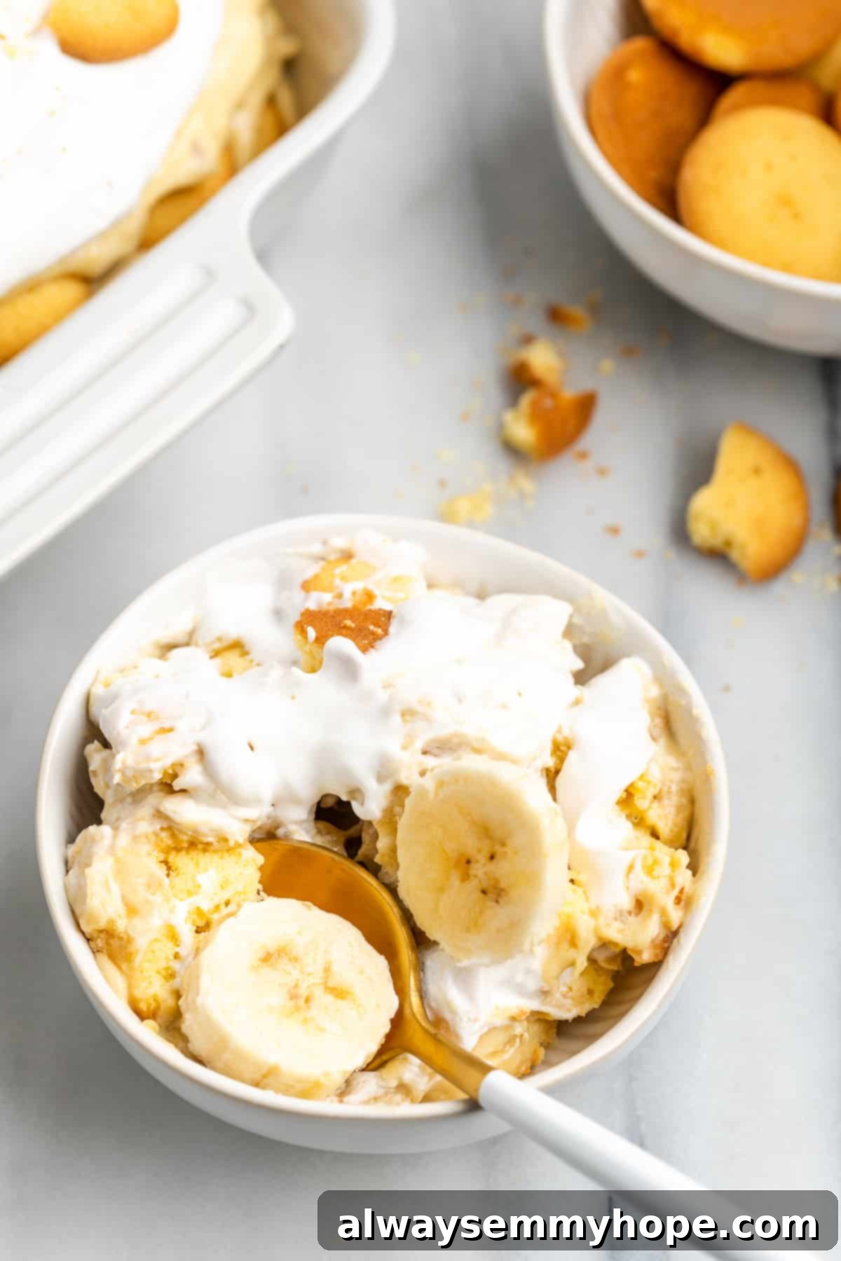 Close-up of a bowl of vegan banana pudding with a spoon digging in, showing the creamy texture and layers