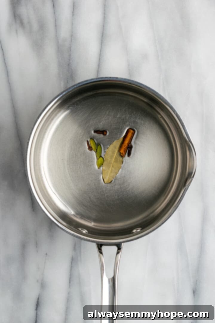 Whole spices and bay leaf cooking in oil in saucepan