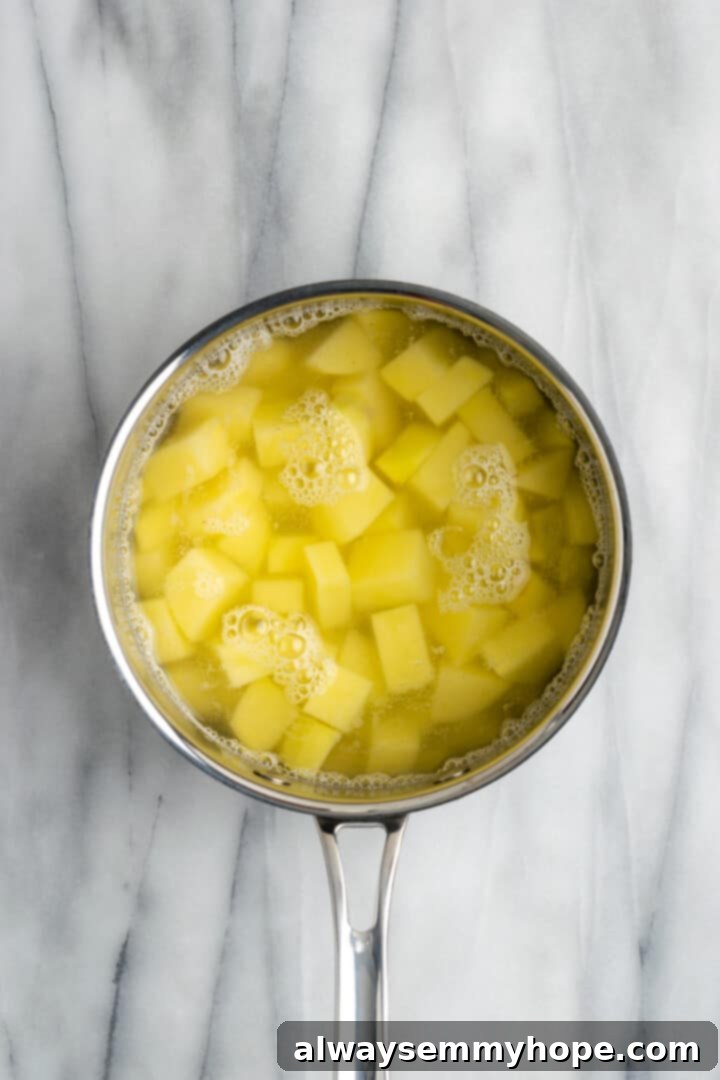 Overhead view of potatoes covered in water in saucepan