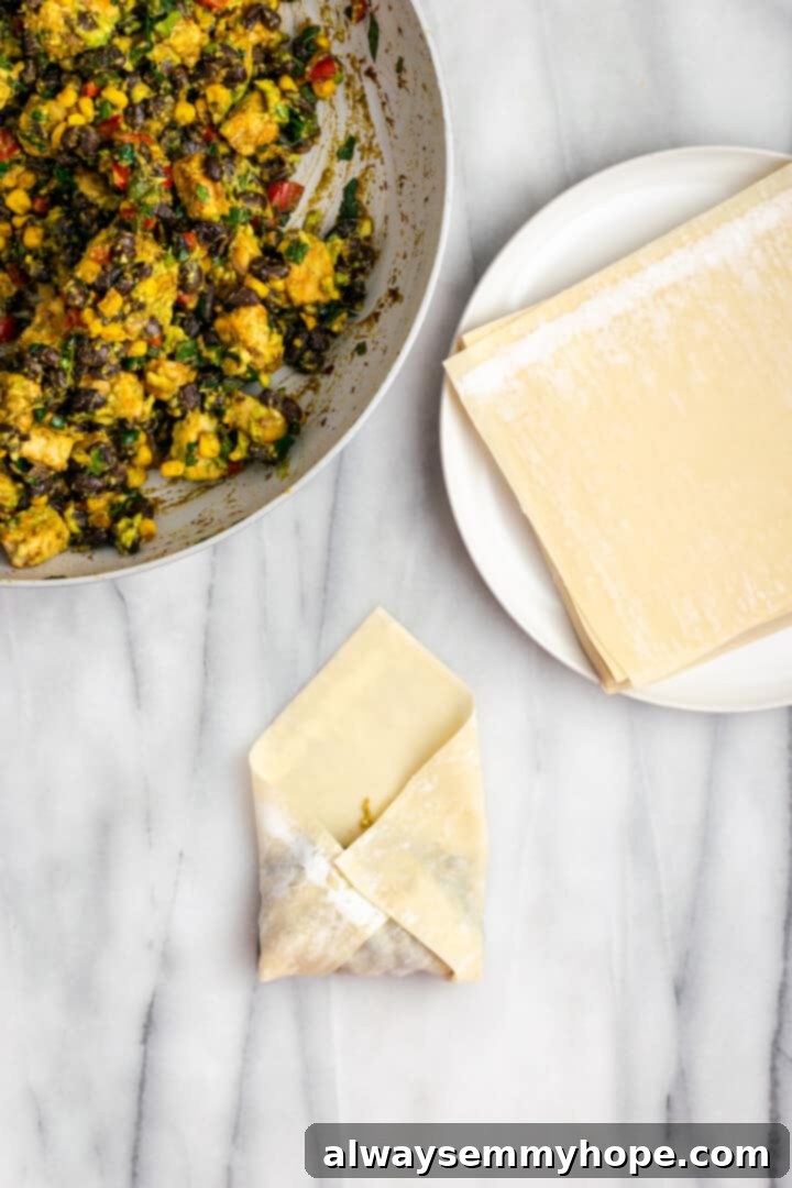 Folding in corners of egg roll wrapper to seal in filling