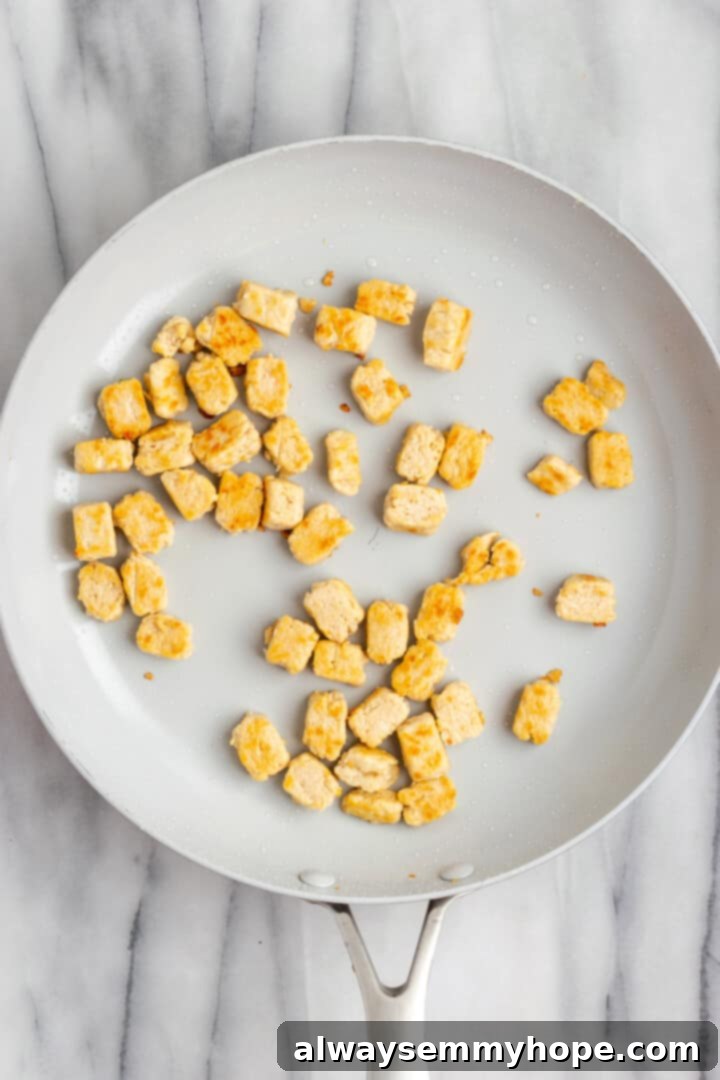 Overhead view of vegan chicken cooking in skillet