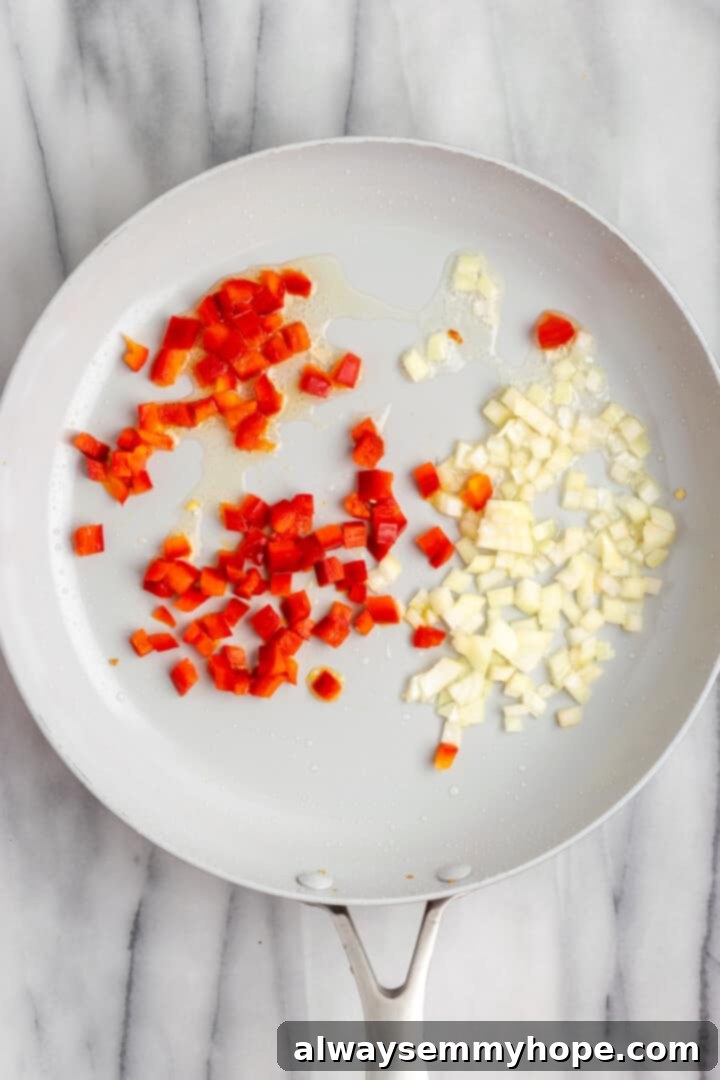 Overhead view of onions and peppers cooking in skillet