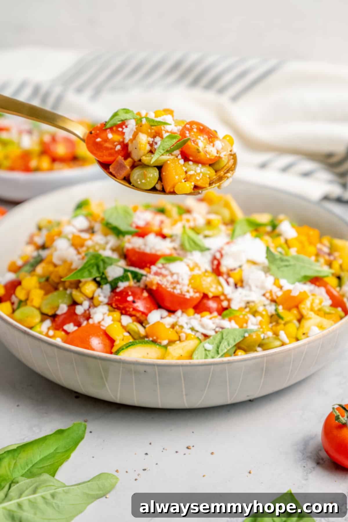 Spoonful of corn succotash held over bowl