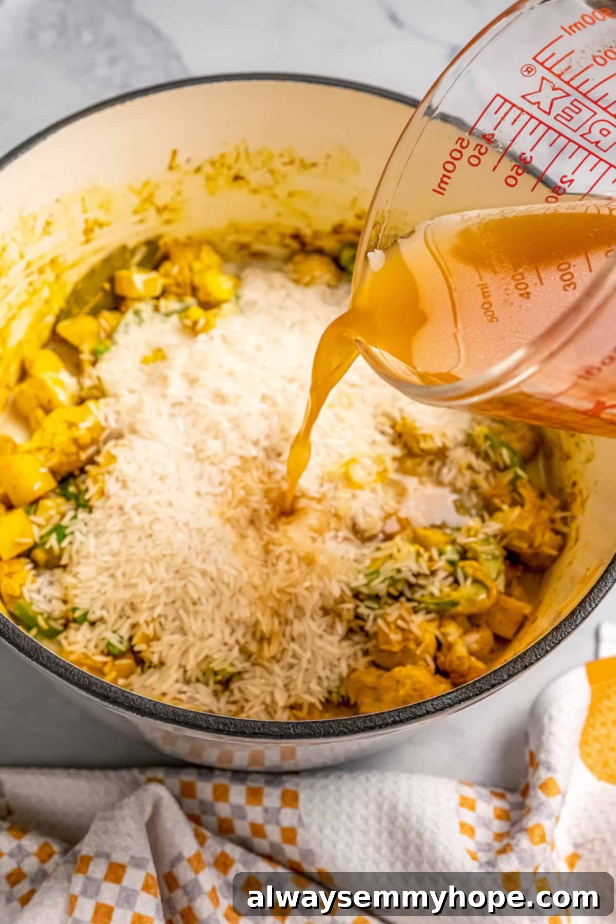 Combining Rice, Broth, and Coconut Milk for Biryani Pouring vegetable broth and coconut milk into a pot containing basmati rice and cooked vegetable-spice mixture.