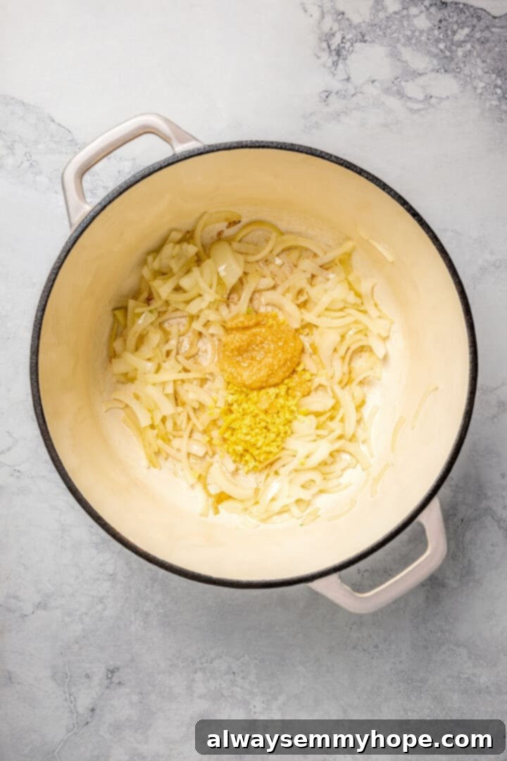 Cooking Aromatics: Ginger, Garlic, and Onions A mix of softened onions, minced ginger, and minced garlic cooking together in a pot.