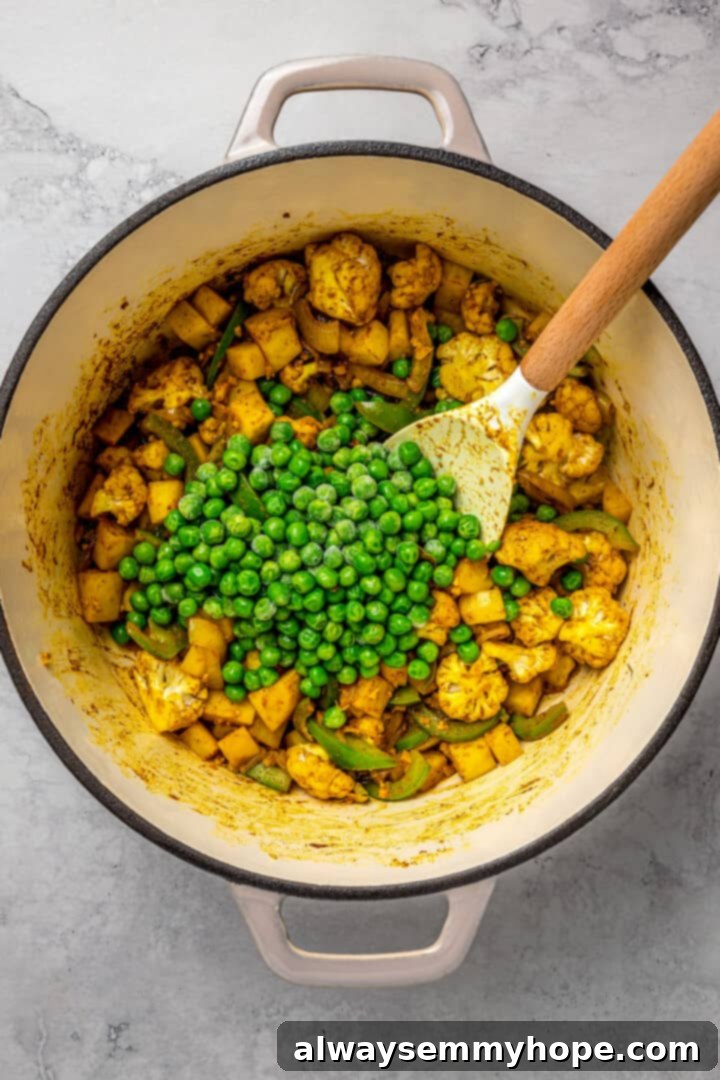 Incorporating Peas into Vegetable Biryani Stirring frozen peas into a pot of partially cooked vegetables and spices.