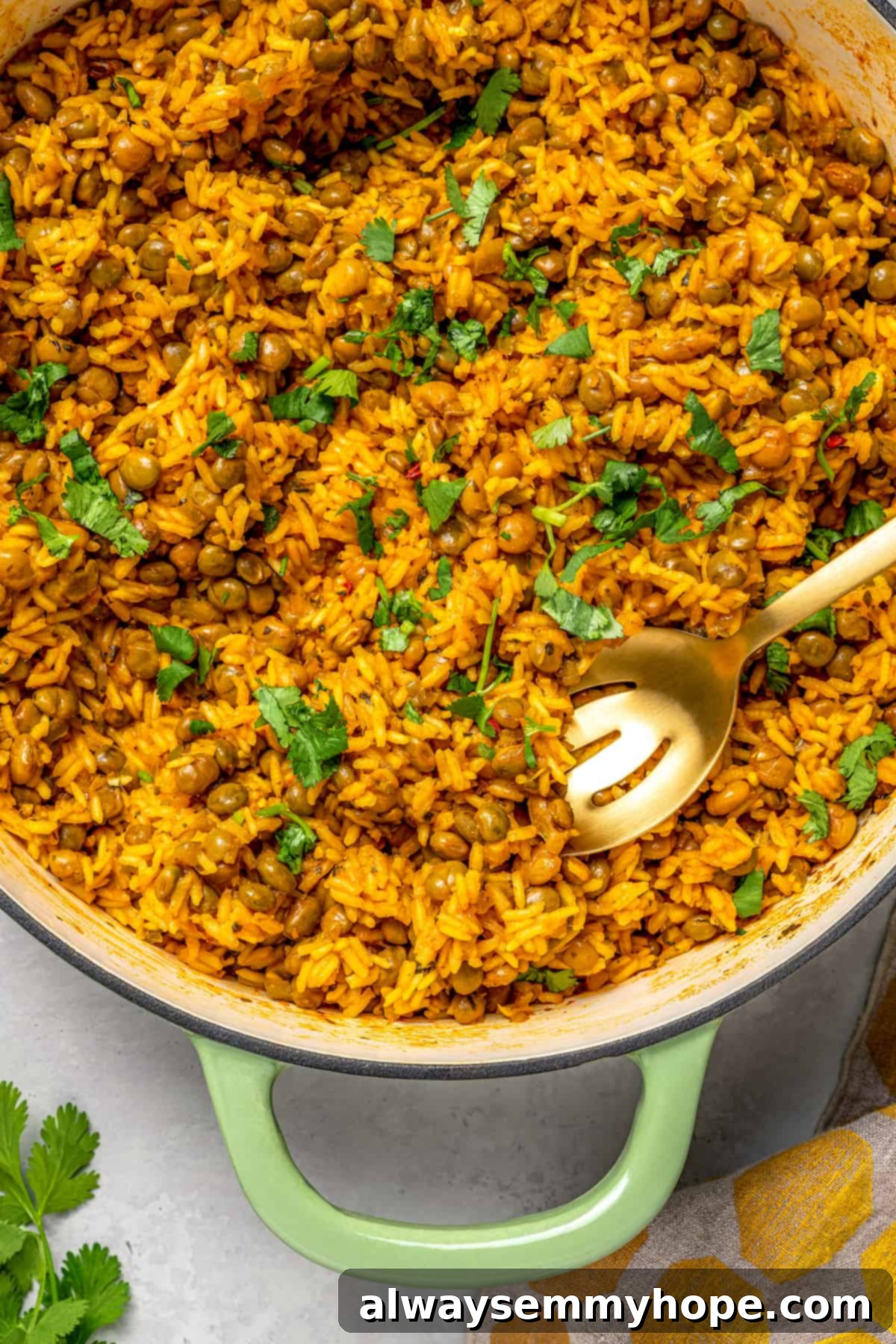 Overhead view of Puerto Rican rice and beans in a cast iron pot with a slotted spoon, ready for serving.