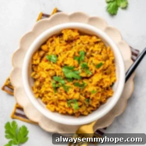 Overhead view of vegan Puerto Rican rice and beans in bowl set on plate with fork