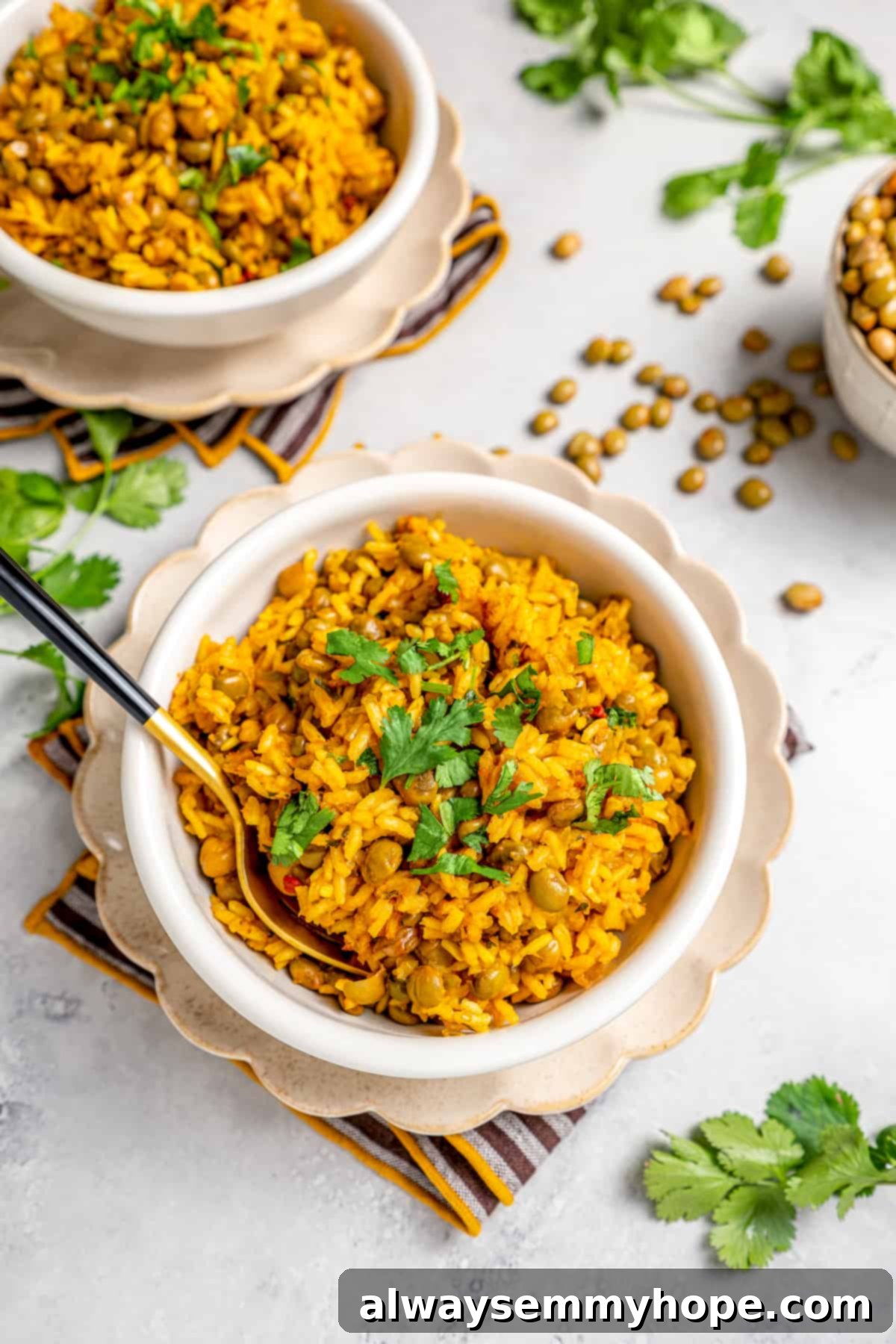 Overhead view of two inviting bowls of Puerto Rican rice and beans, with scattered beans and fresh cilantro on the tabletop, ready to be served.